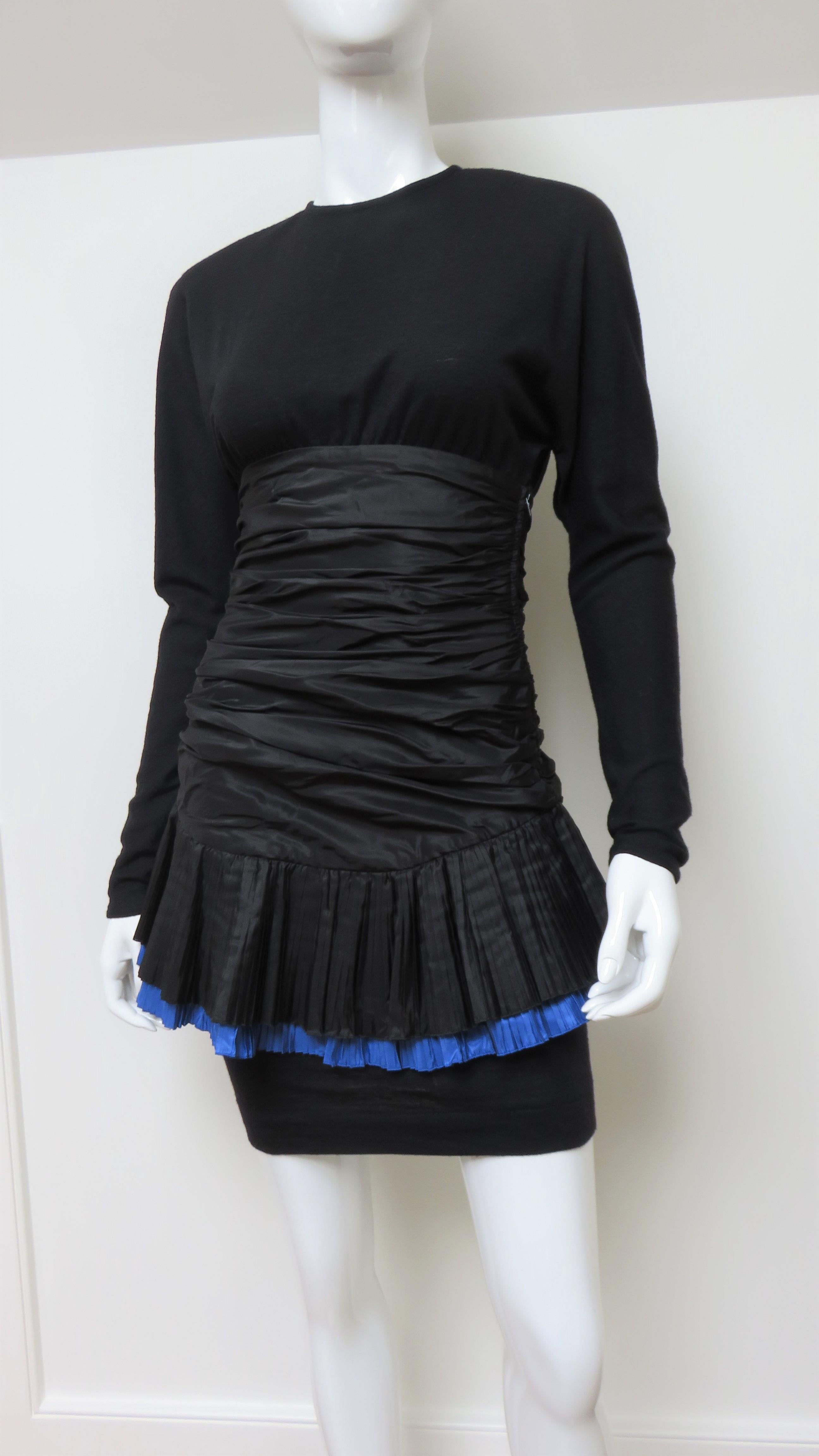 A pretty black wool jersey and silk dress from Angelo Tarlazzi.  It has long sleeves, a crew neckline, dolman sleeves and a straight skirt all in wool jersery.  The silk waist is horizontally ruched with a 2 layer peplum at the hip one black, one
