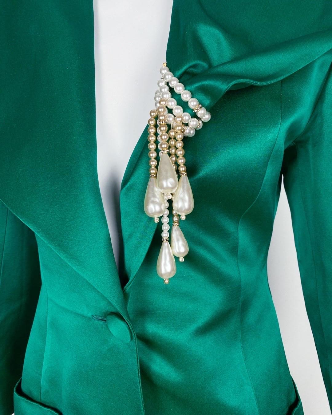 Fai una dichiarazione audace con questo straordinario tailleur con gonna in seta verde smeraldo dello stilista italiano Angelo Tarlazzi, risalente agli anni Ottanta. Conosciuto per la sua sartoria raffinata e drammatica, Tarlazzi conferisce a questo
