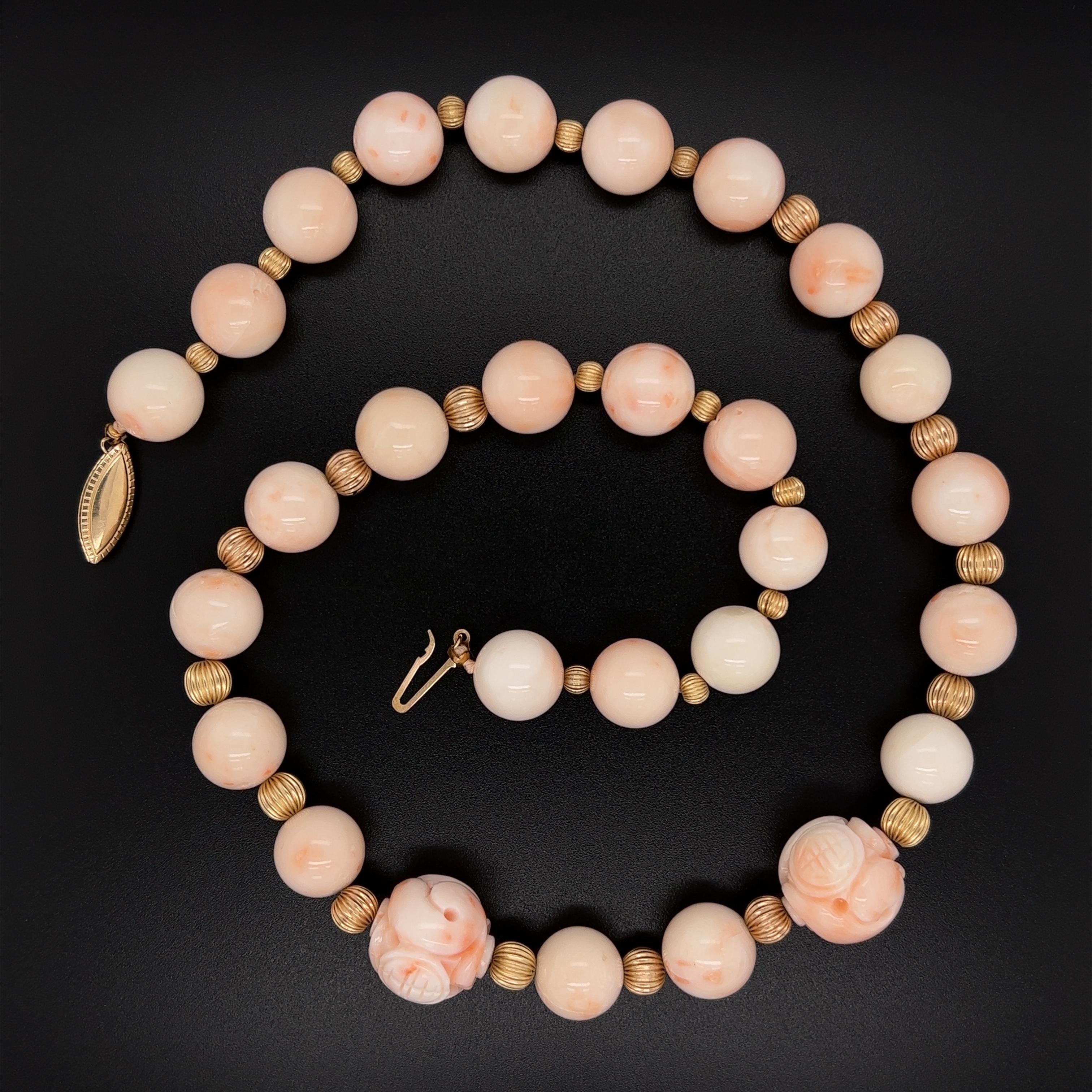 Tout simplement magnifique ! Collier de Corail rouge, comprenant 28 perles de Corail, dont 2 perles de Corail sculpté, chacune mesurant environ 11mm-15.8mm, intercalées avec des perles nervurées en or 14K. Maintenu par un fermoir en or jaune 14K.