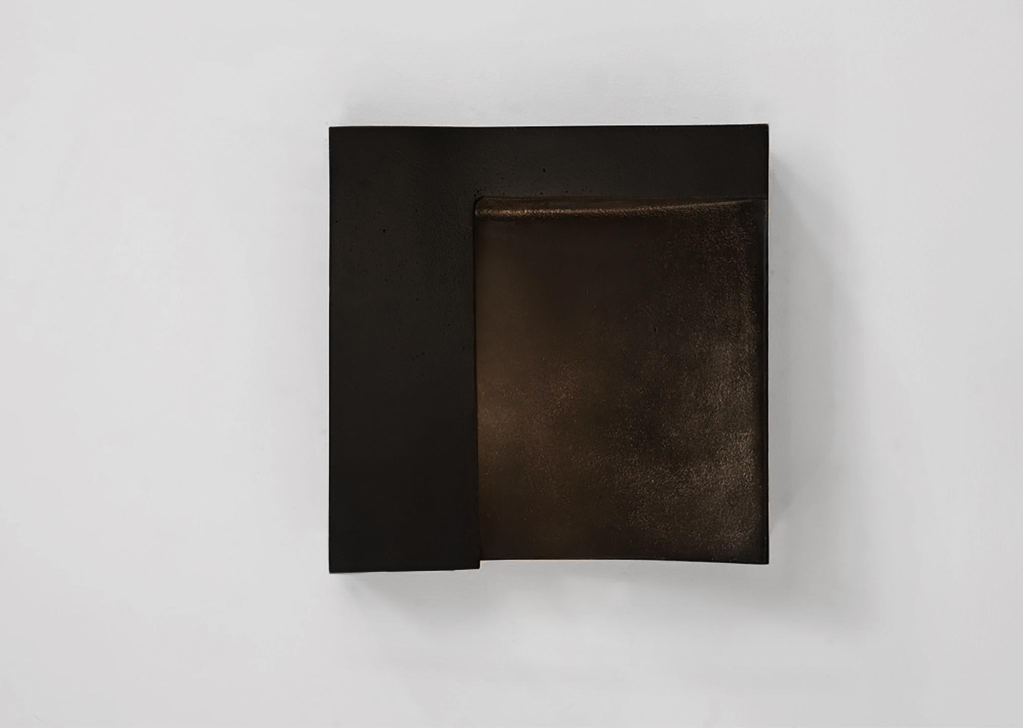 The Angle is a sculptural wall light in cast aluminum. A sweeping arc of light is carved into the face of the fixture bringing balance to its Brutalist form. The casting is finished to a smooth texture and is available in satin aluminum, bronze or