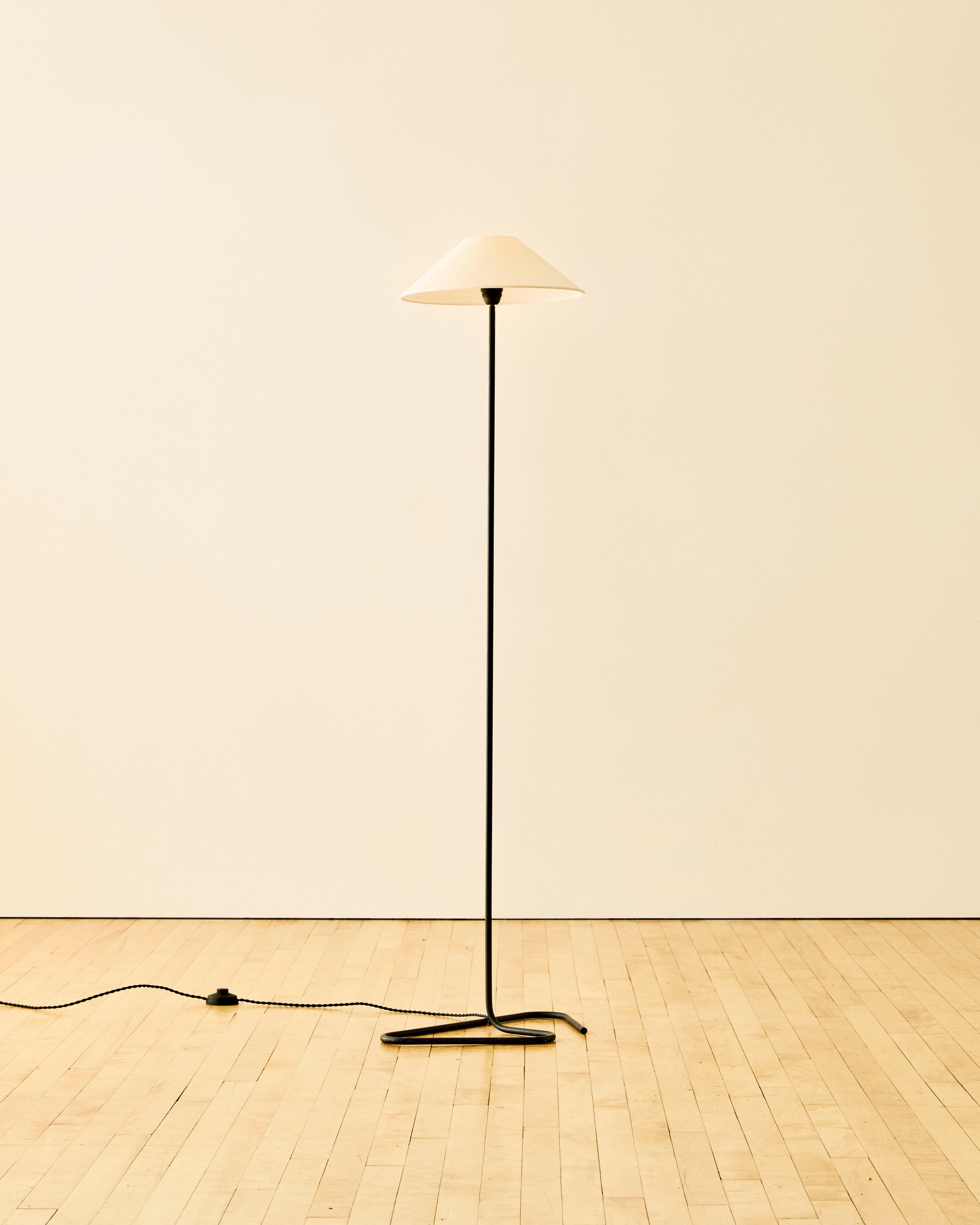 Metal floor lamp C. 1950 featuring a contemporary shade and angled base.