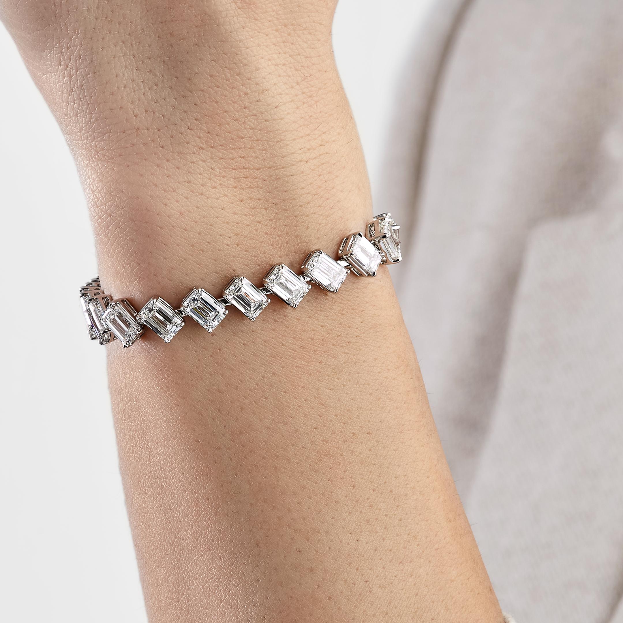 This angled set tennis bracelet is a true statement of elegance, featuring emerald-cut diamonds arranged at a distinctive angle for a unique look. The Ella emerald cut diamond bracelet it set in 18K White Gold, 24 diamonds totaling 24.20 carats are