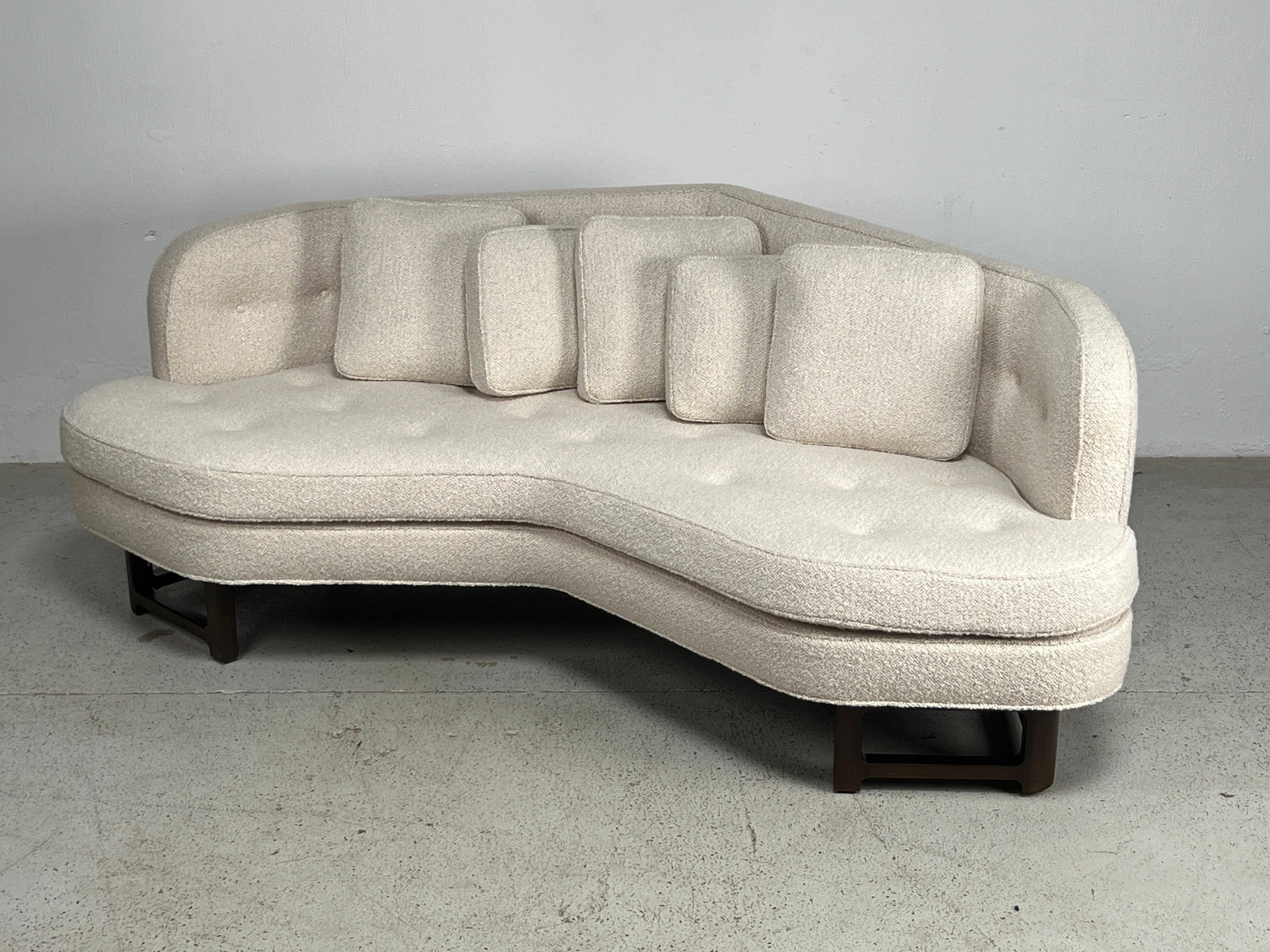 An angled sofa designed by Edward Wormley for Dunbar. Beautifully restored with refinished mahogany base and reupholstered in Holly Hunt / Chalet / Snow. New down pillows.