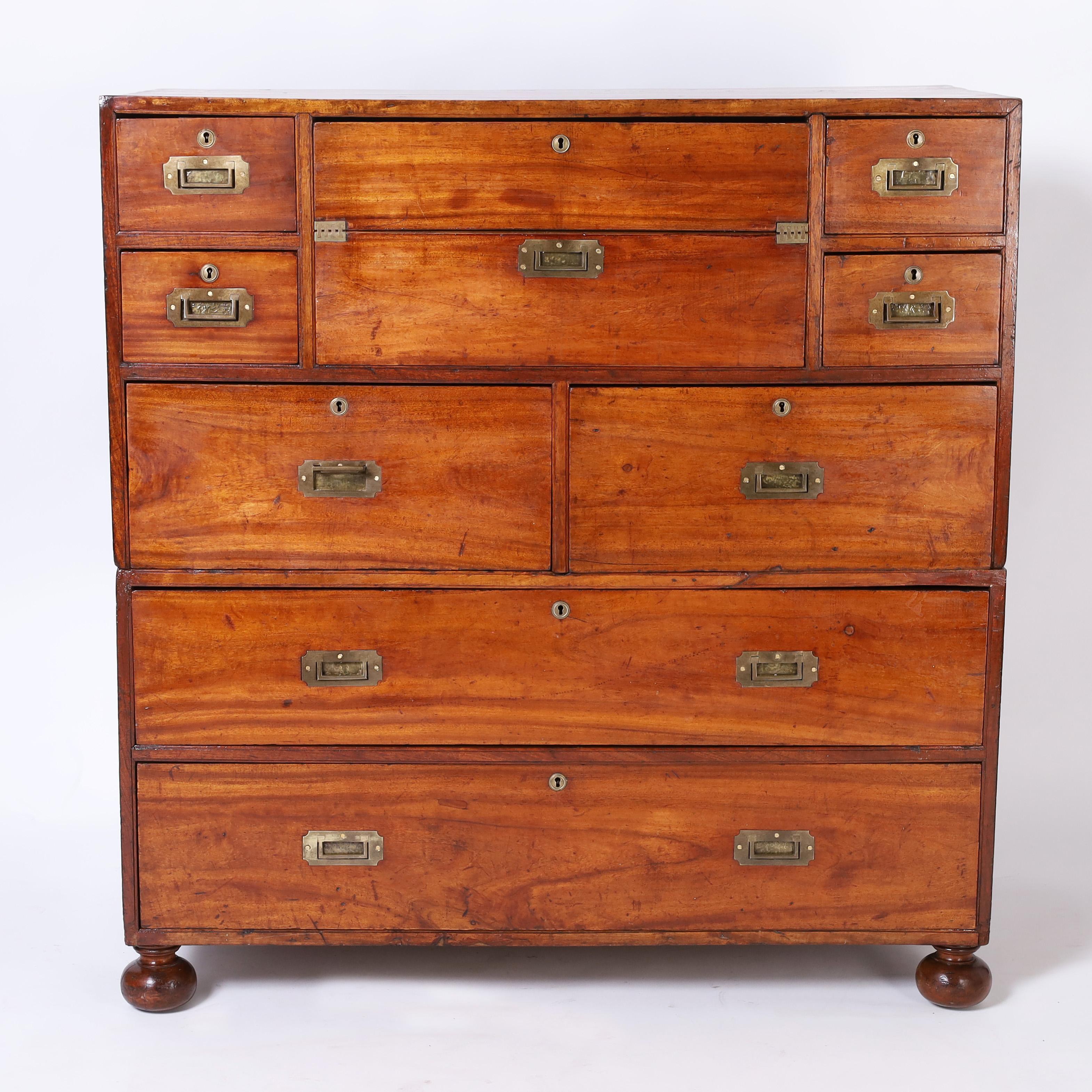 Rare and remarkable 19th century Anglo Chinese chest with eight drawers handcrafted in teak in two piece construction, having a pullout desk with leather writing surface, storage compartments, nooks and crannies, brass campaign hardware and turned