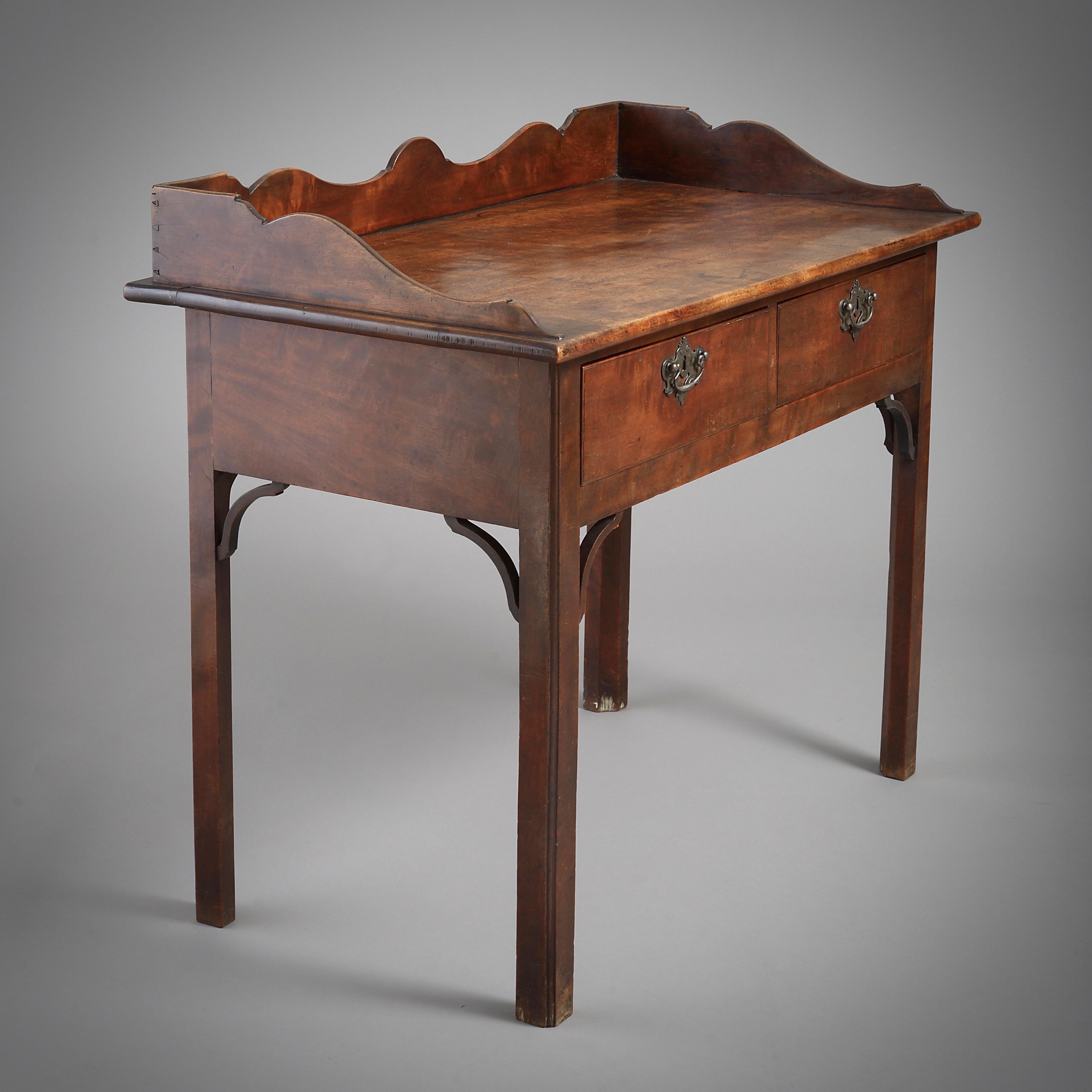 An Anglo-Chinese George III padouk side table, with original paktong handles, circa 1760.

Measures: 34.5 in. (87cm) to top of gallery.