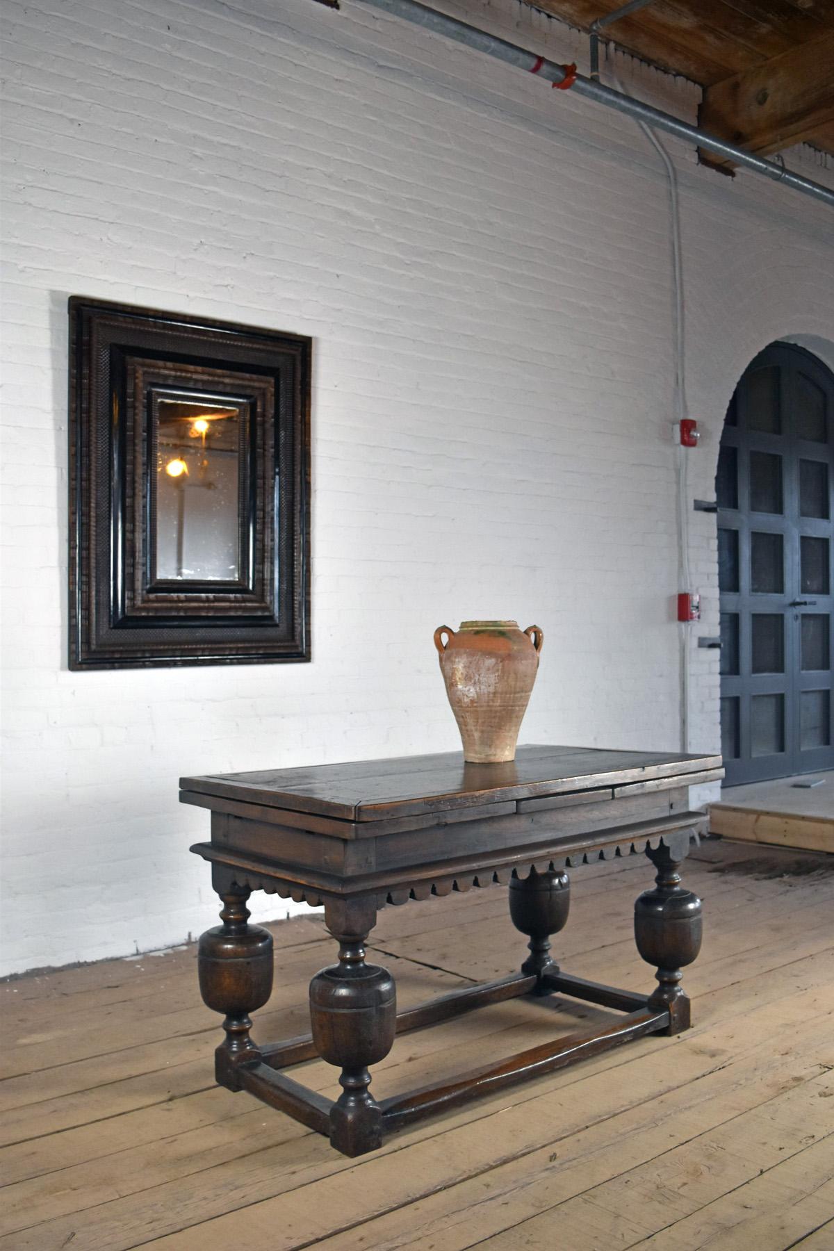 Very versatile table of bold, strong personality and sculptural form, to be used open or closed, as centre- dining-, library- serving or console table. Of Dutch origin after English designs, the oblong top with extension leaves on both sides,