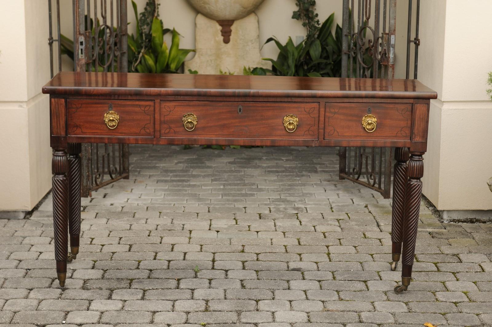 An Anglo-Indian mahogany server from the mid-19th century, with three drawers and twisted turned legs on casters. This exquisite mahogany serving table features a rectangular top sitting above three lovely drawers, each adorned with delicate inlay