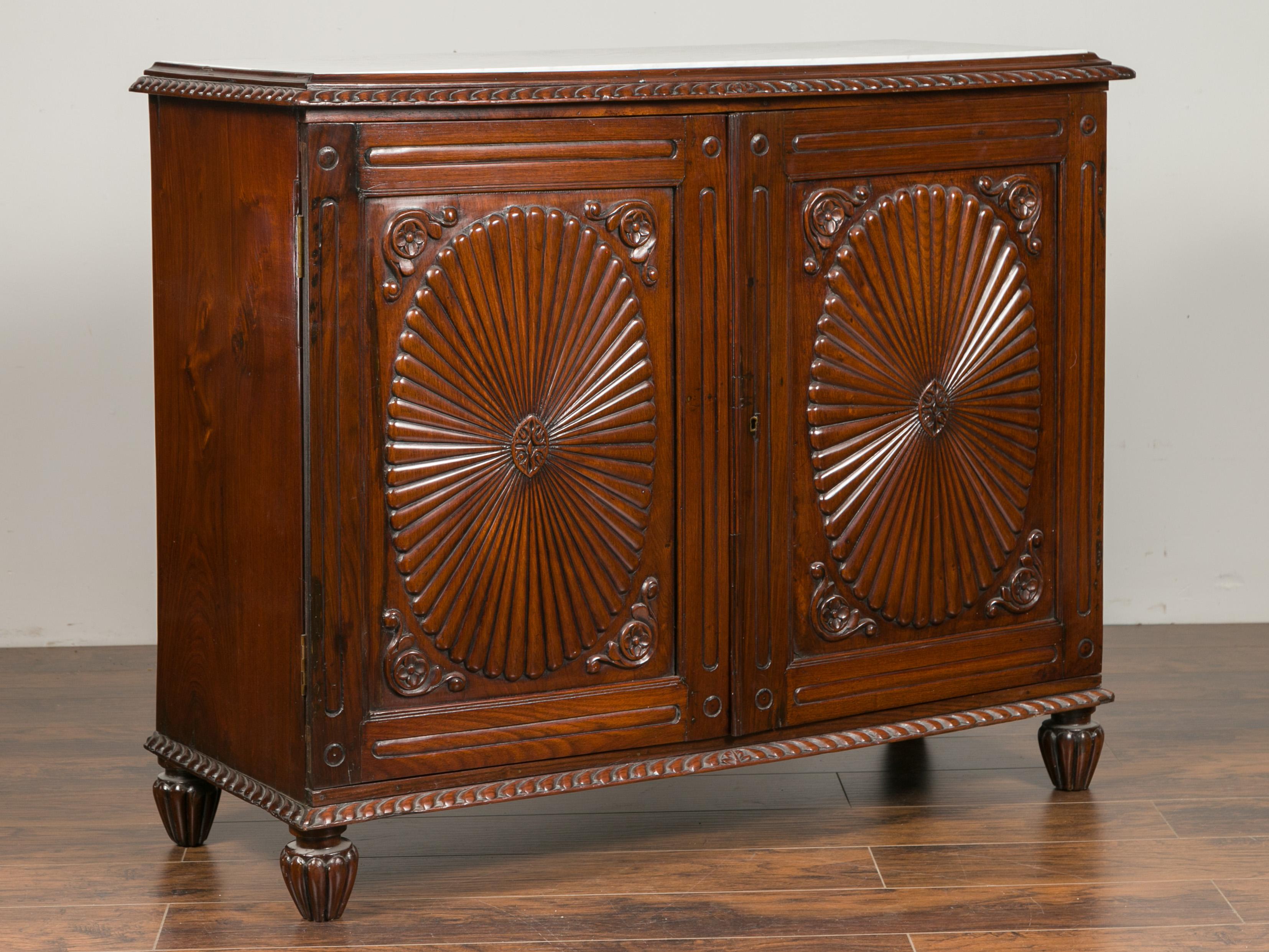 An Anglo-Indian mahogany buffet from the late 19th century, with reeded oval radiating motifs and white veined marble top. Crafted during the last quarter of the 19th century, this mahogany buffet features a white veined inset marble top, resting