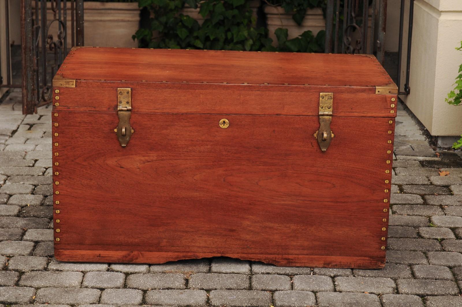 An Anglo-Indian teak trunk from the late 19th century, with multiple storage compartments and brass accents. Born in the later years of the 19th century, this exquisite teak wood trunk features a linear silhouette, beautifully accented with brass