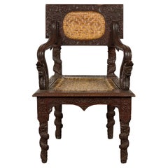 Anglo-Indian 1900 Armchair with Carved Back, Mythical Creatures and Woven Rattan