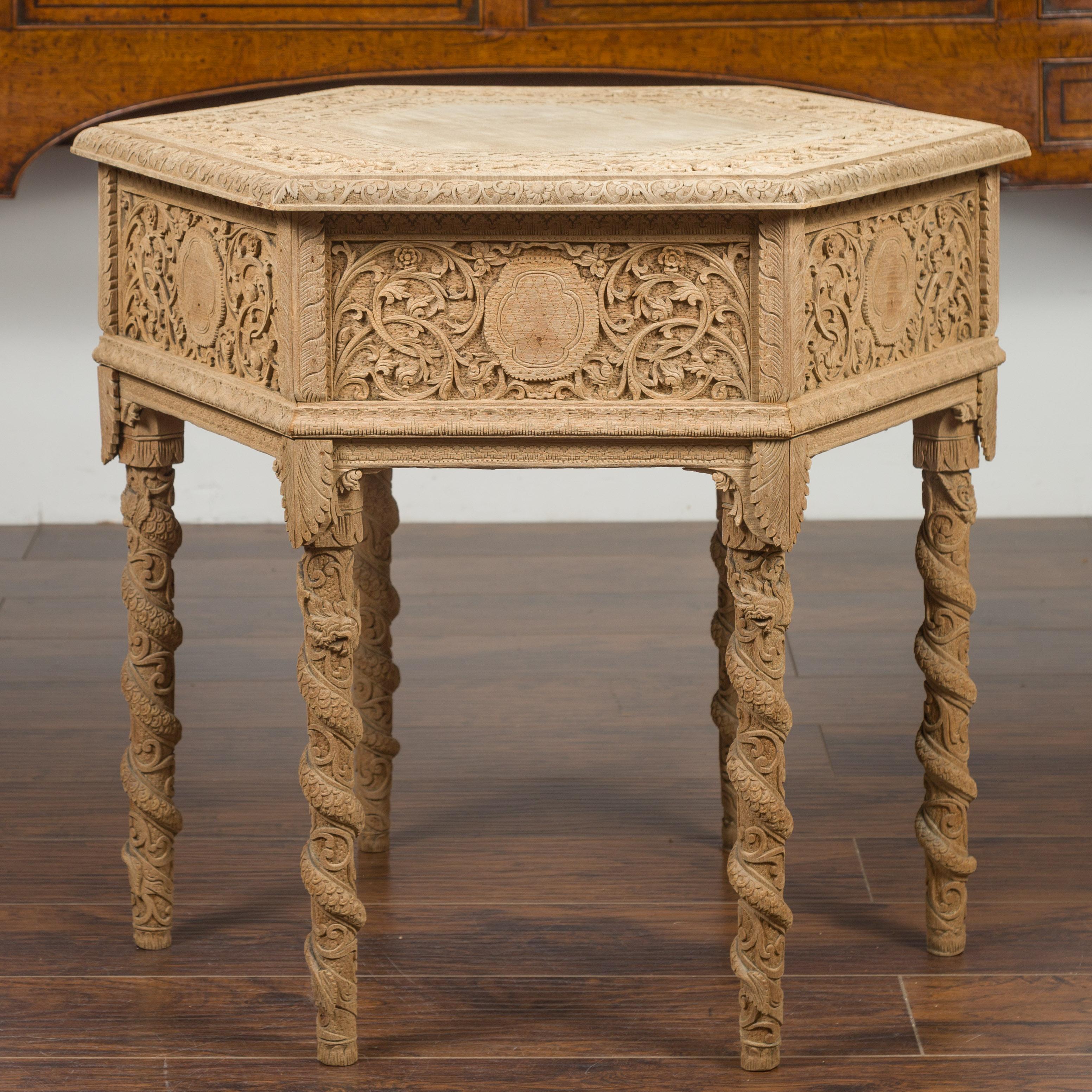 An Anglo-Indian bleached wood side table from the early 20th century, with hexagonal top and carved rinceaux. Created in India during the first quarter of the 20th century, this bleached wood side table features an hexagonal top adorned with