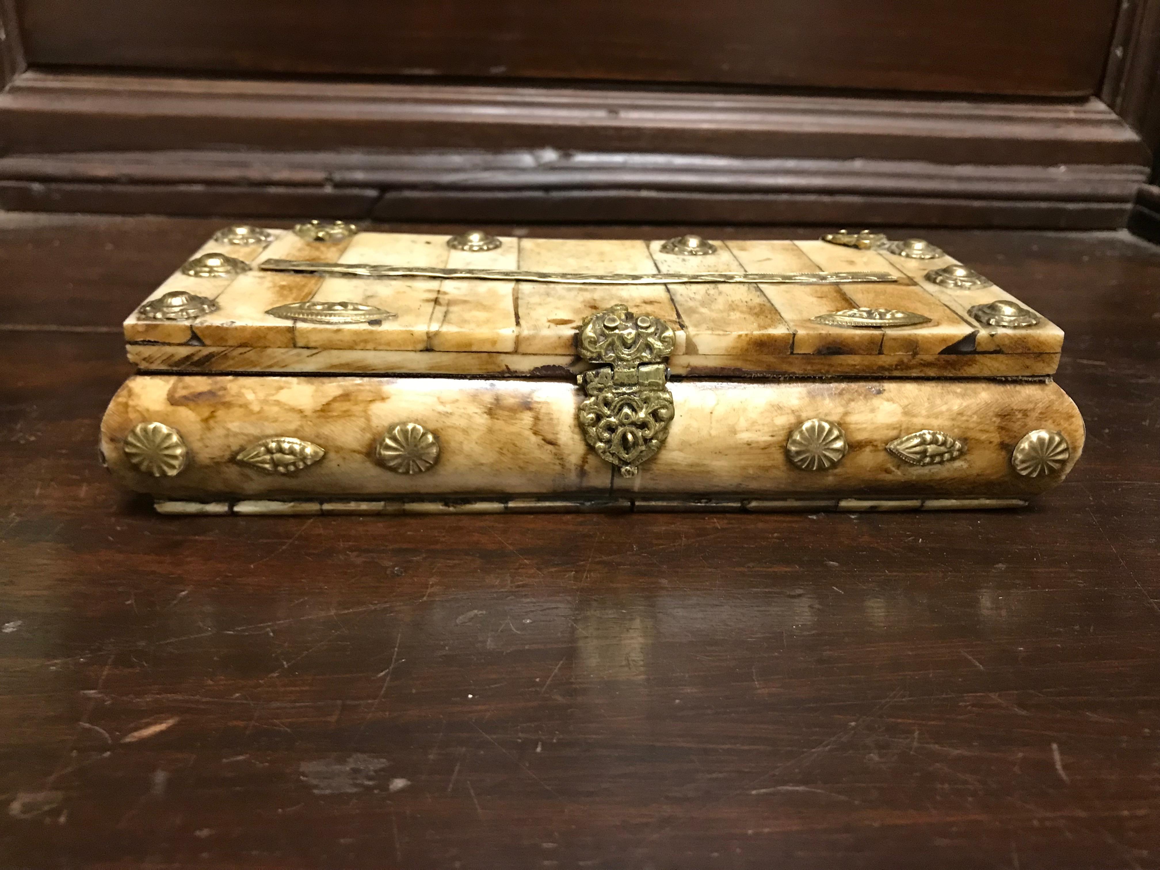 An handsome and quite distinctive Anglo-Indian box of unusual construction. Made of thick bone plaques with repousse brass decorations, hinges and hasp. Lined with black cloth. A fine addition to a box collection, or a singular addition to any