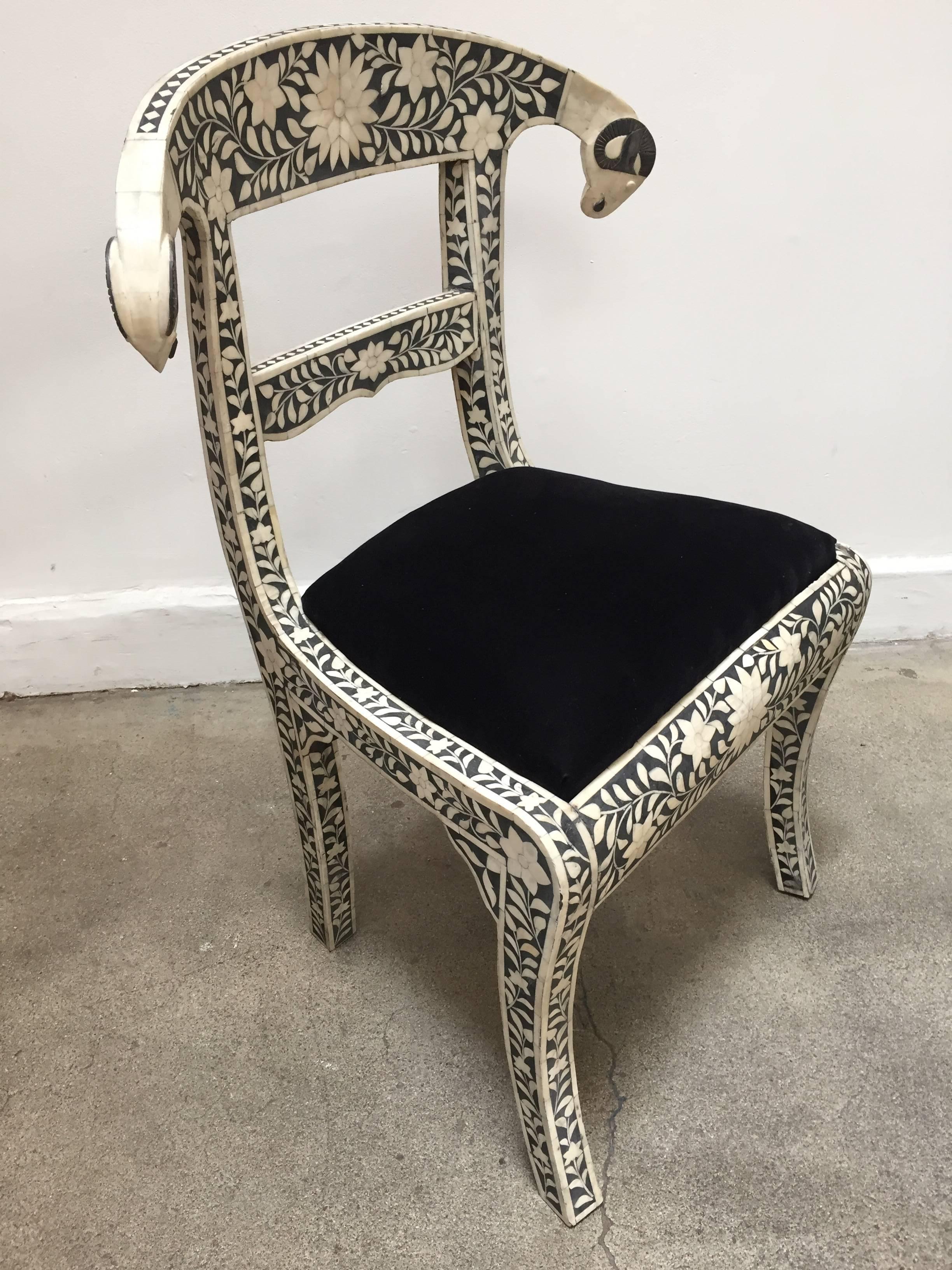 Anglo-Indian black and white dowry side chair with ram's head.
This stunning chair feature a wooden frame inlaid with intricate and detailed floral design in white and black color and scrolling ram's heads finish.
Seat is upholstered in a black