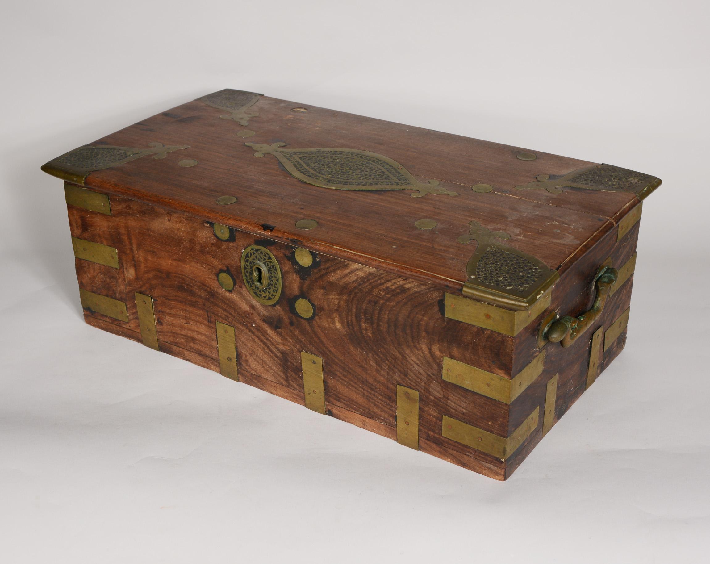 Anglo Indian hardwood campaign or dowry chest. This has brass straps, handles and large hinges on the interior. The lock has the original key. The chest is in good condition. It shows lots of wear from age. One hinge is missing an attachment stud.