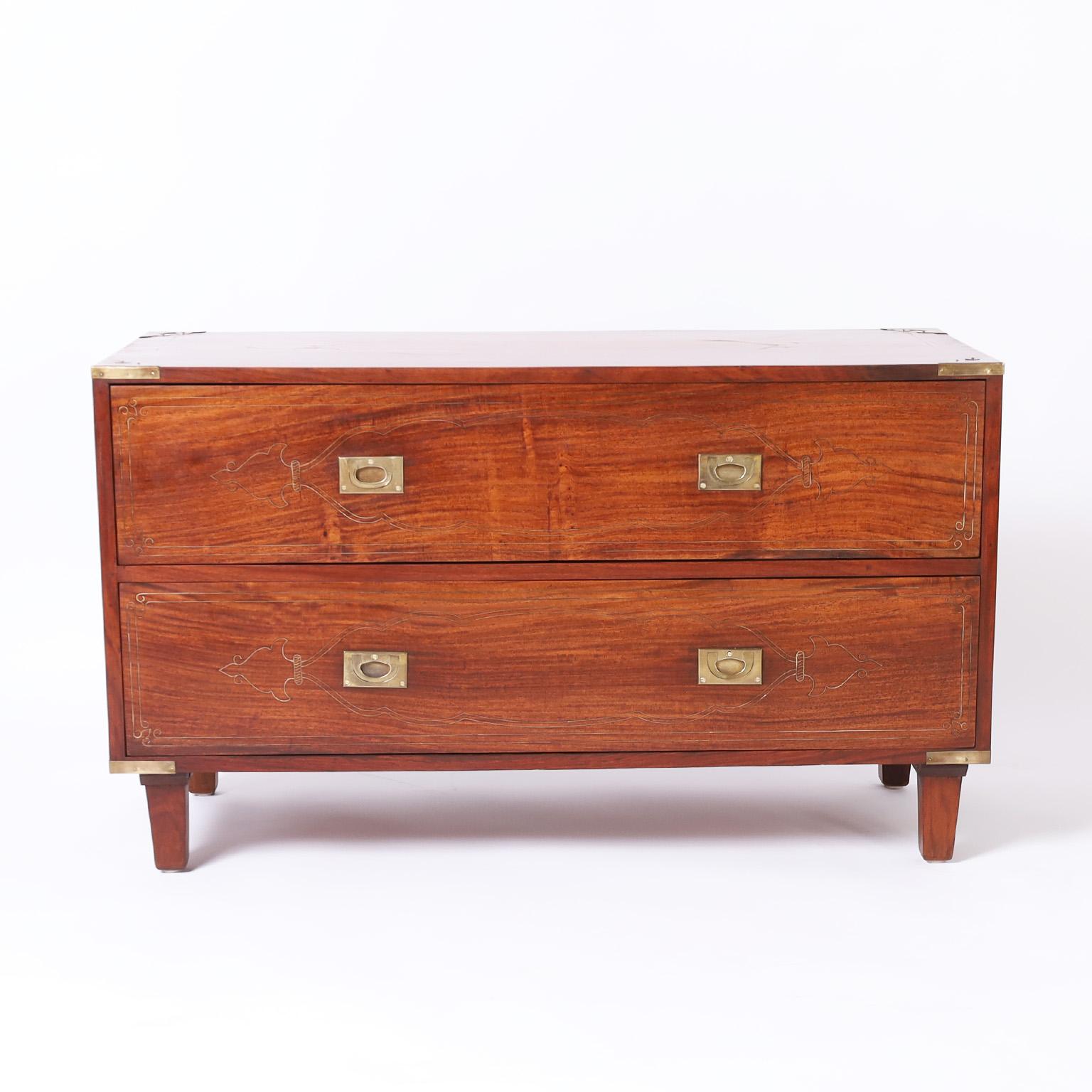 Mid century Anglo Indian chest crafted in mahogany with two drawers in a campaign style featuring brass string inlays, brass hardware, and tapered feet.