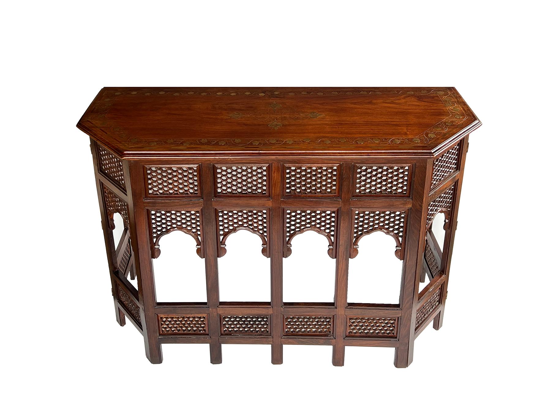 this rare find was originally used as a traveling table in British Colonial India where the hinged base would fold for easy travel and fitted with a removable top; the rectangular top with canted corners and ogee edge centering a brass