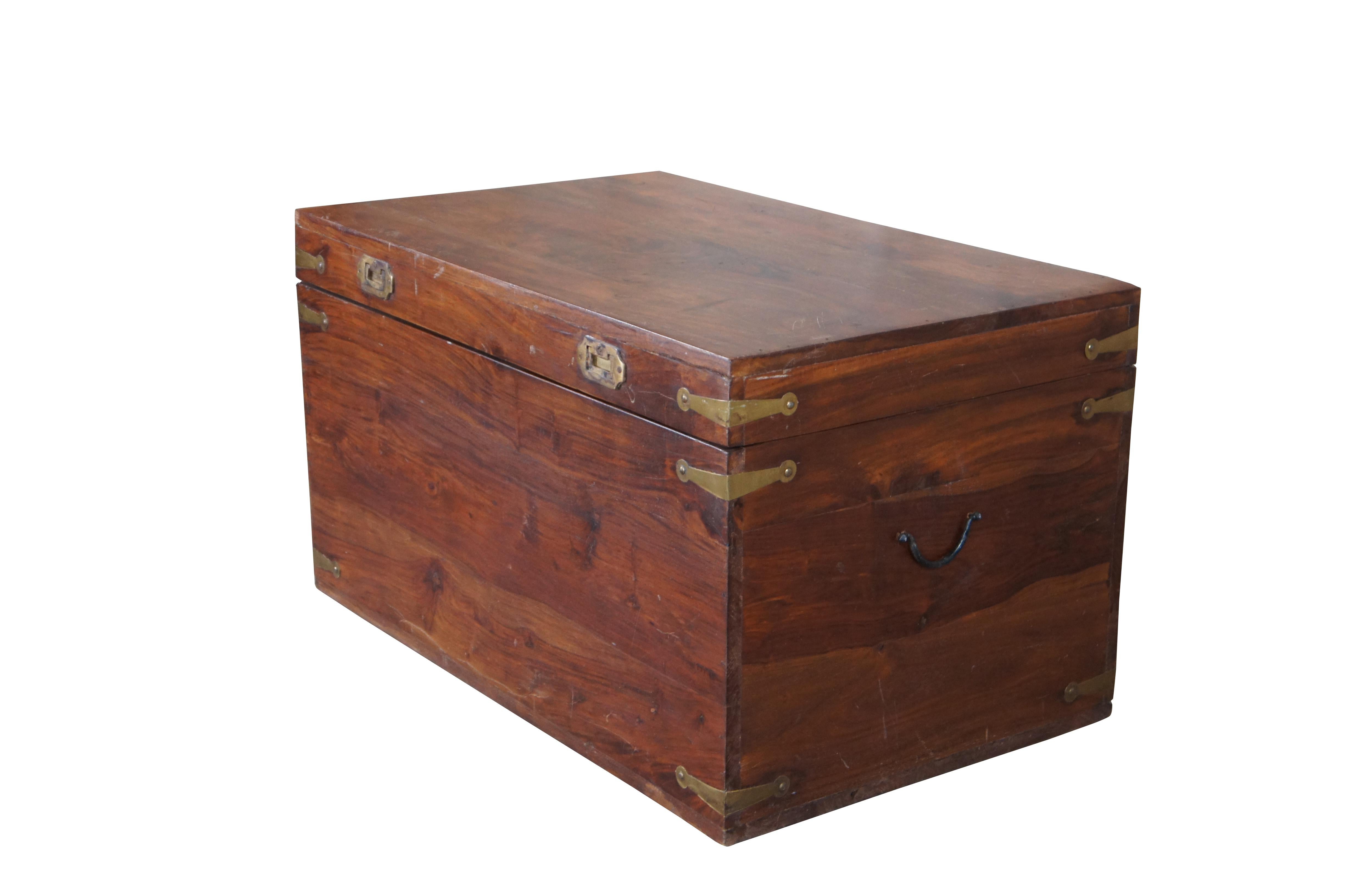 British Colonial style Camphor wood blanket storage chest or coffee table. Features a nice patina with brass accents and iron handles. Brass handles along the front are recessed. Trunk has a stop along the back side to keep the top open. Circa