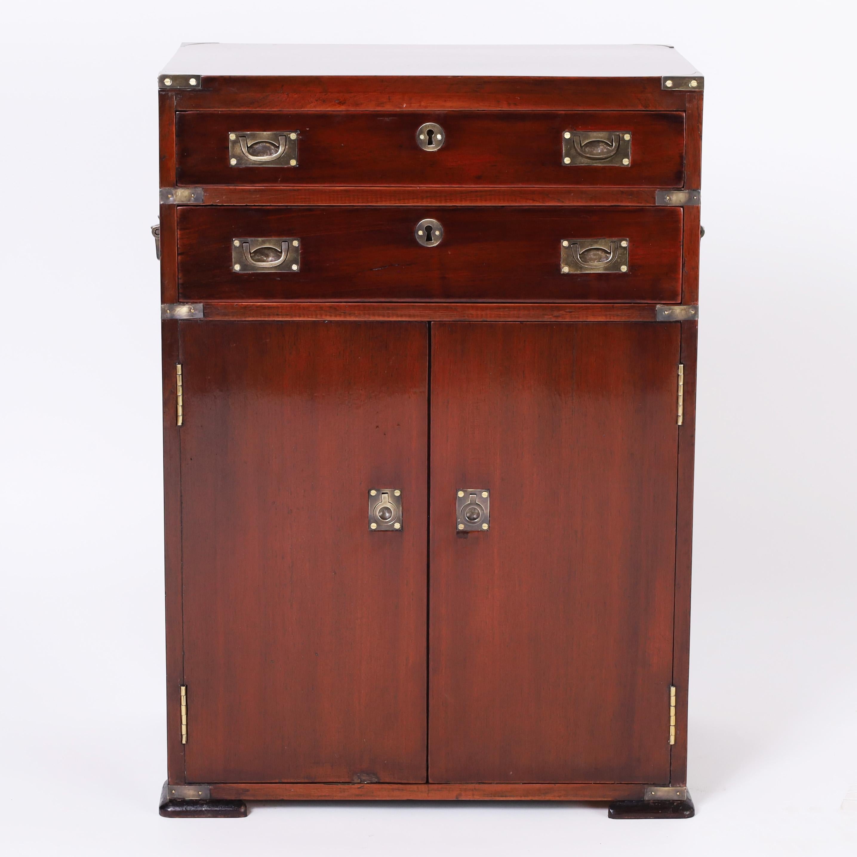 Handsome antique Anglo Indian campaign cabinet crafted in mahogany featuring a finish French polished in the traditional old world manner, brass hardware, two drawers, and pad feet. Interesting note this piece passed through an antique auction in