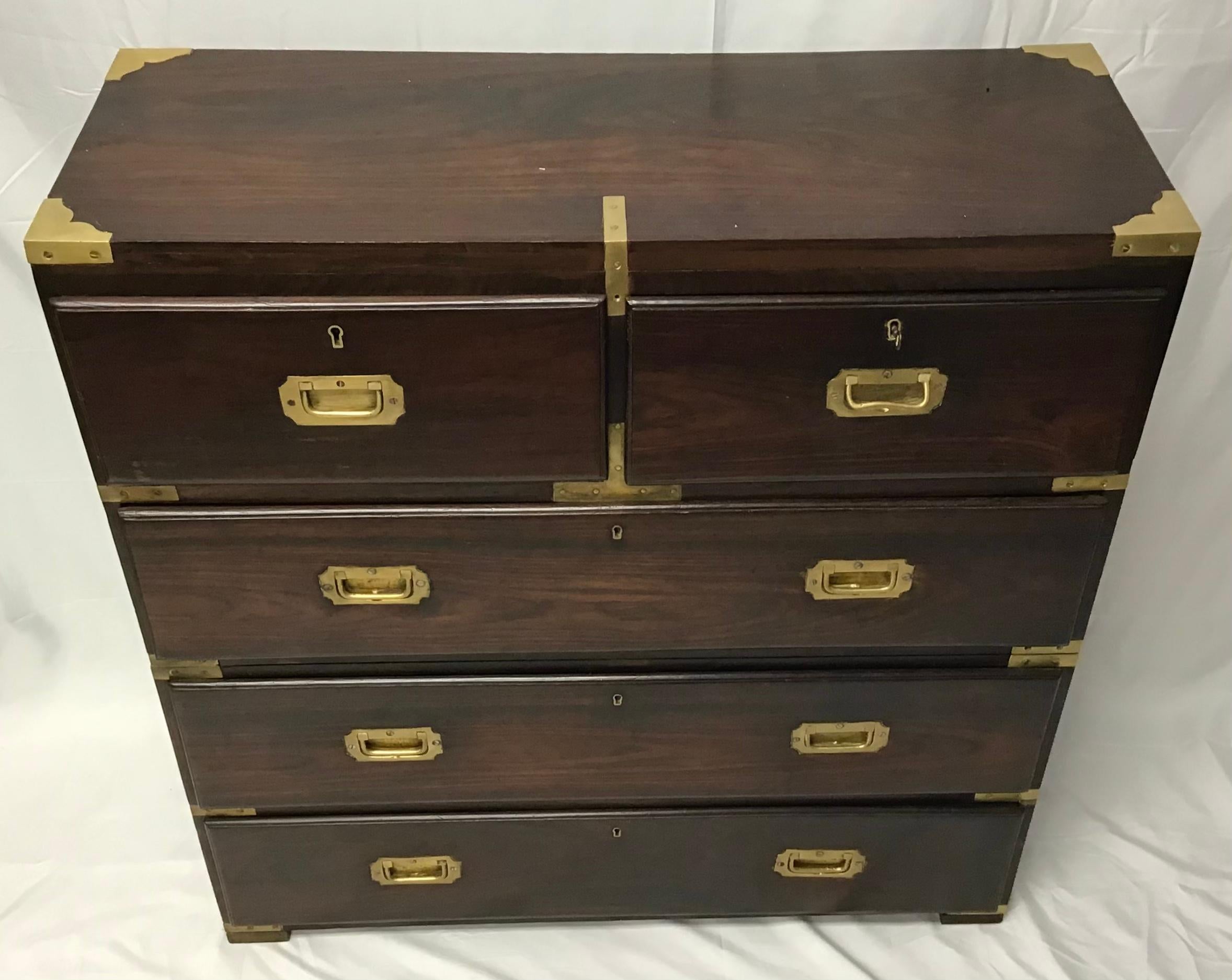 A two-part rosewood Anglo Indian campaign chest. Each section fitted with brass handles on each side and protective brass corner mounts. Each drawer front with two recessed pulls. The base supported by plinth foot. This piece is constructed with