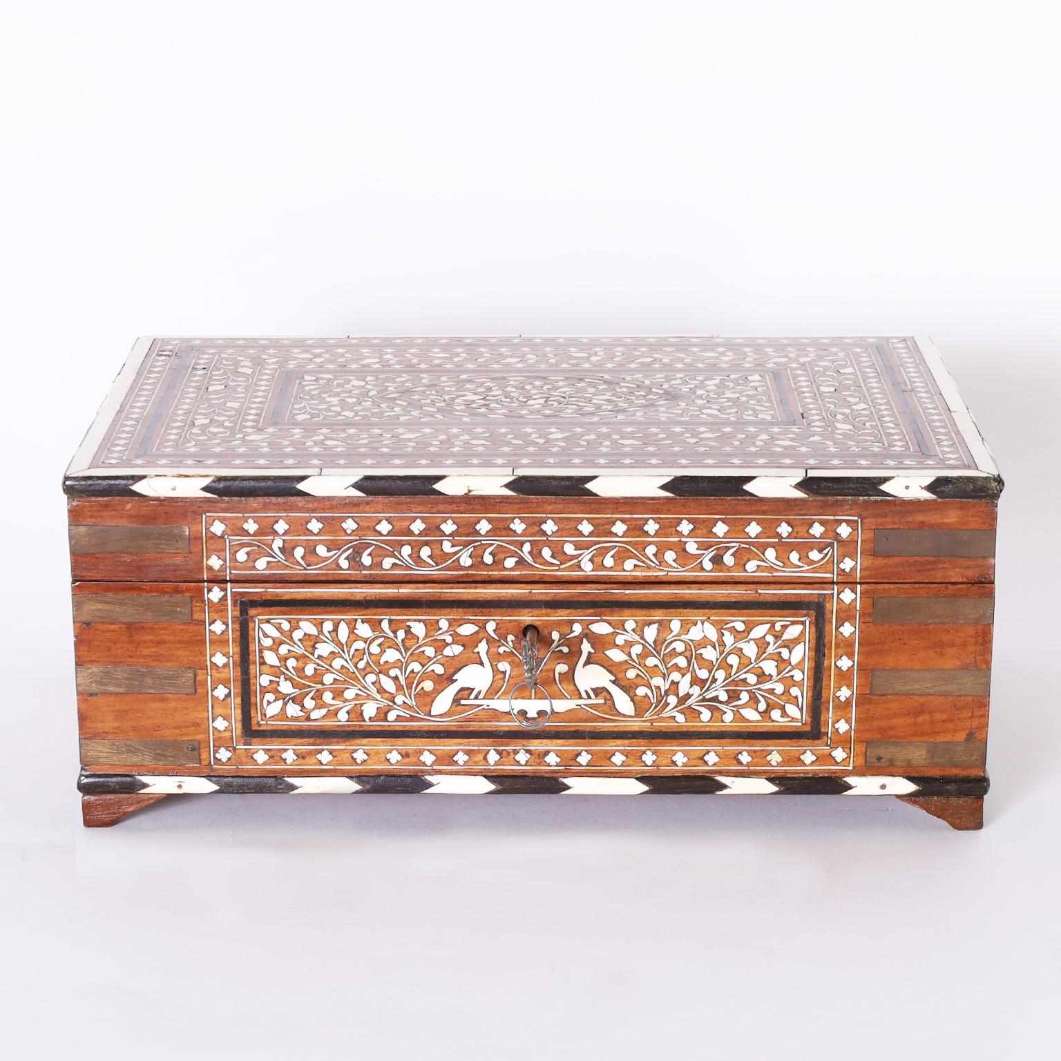 Antique Anglo Indian lidded box decorated with intricate floral and fauna bone inlays and Campaign style brass hardware. The inside has floral inlays with lidded and removable compartments.