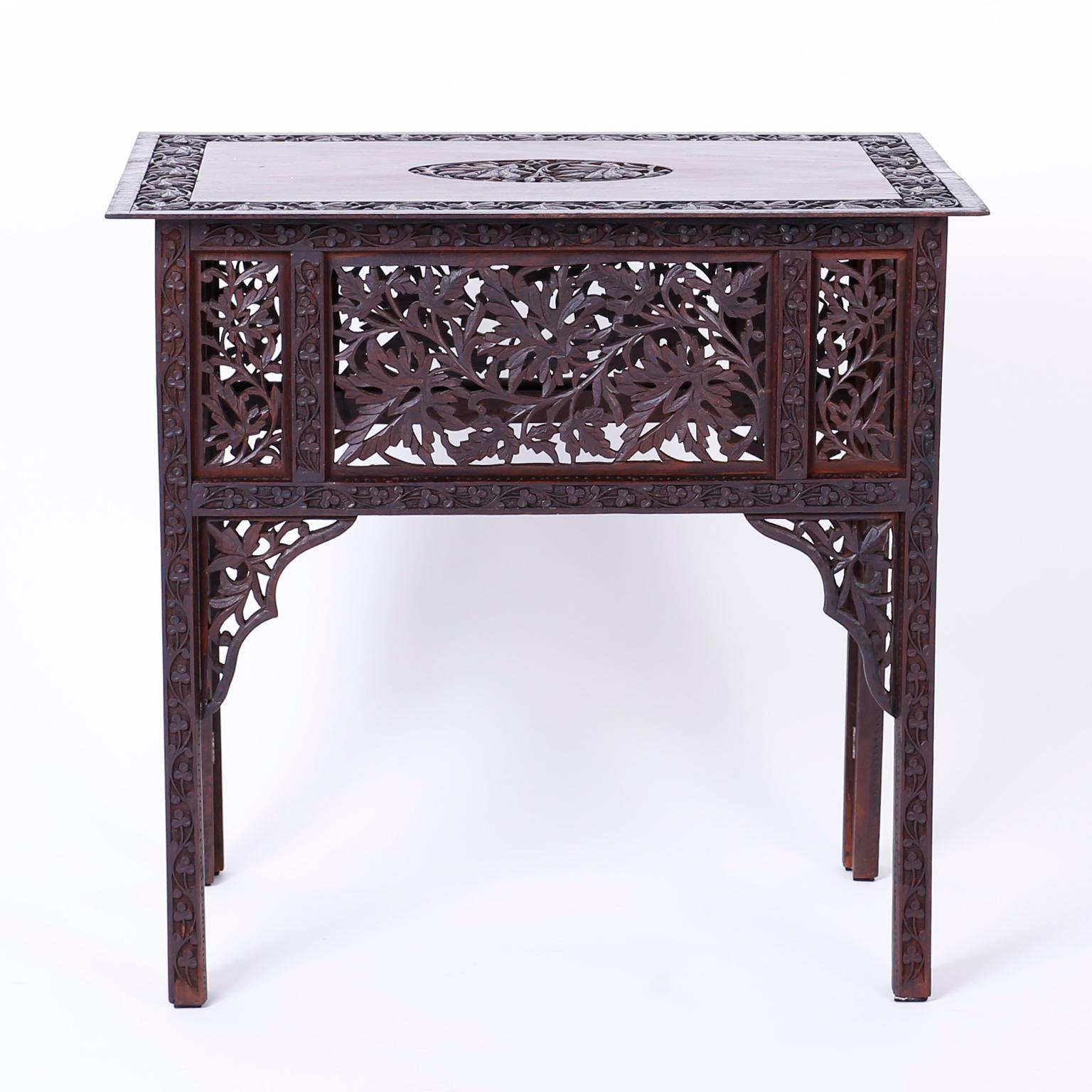 Stand out antique Anglo-Indian Bombay black wood side table or occasional table with expertly carved leaf designs on a center medallion, frame, sides, and bracket supports.
 