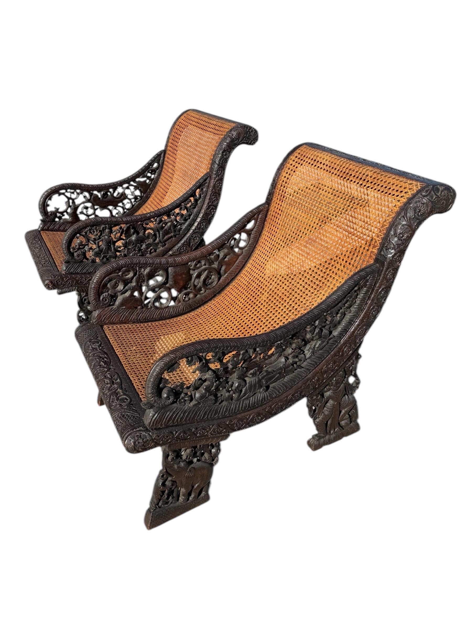 Paire de fauteuils de repos anglo-indiens finement sculptés, vers 1800. Les cadres sont en teck et sont sculptés de manière élaborée avec un feuillage en spirale. Les côtés ajourés, sculptés d'oiseaux, de personnages et de divinités entrelacés, se