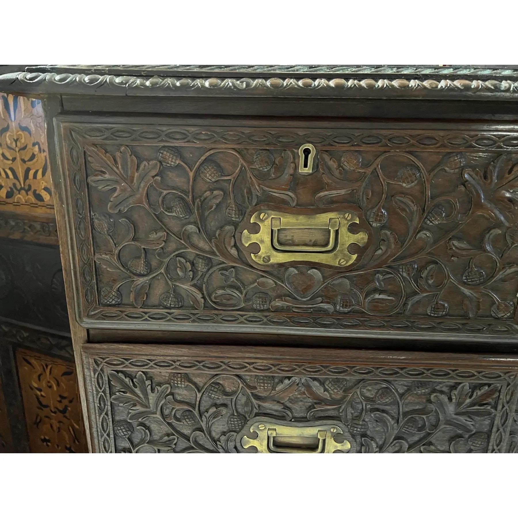 Cassapanca anglo-indiana in teak intagliato, circa 1800. Due o tre cassetti a coda di rondine sono finemente intagliati con foglie e ghiande di Oak e si aprono con maniglie a coda di rondine in ottone. Il mobile è rifinito con un bordo intagliato a