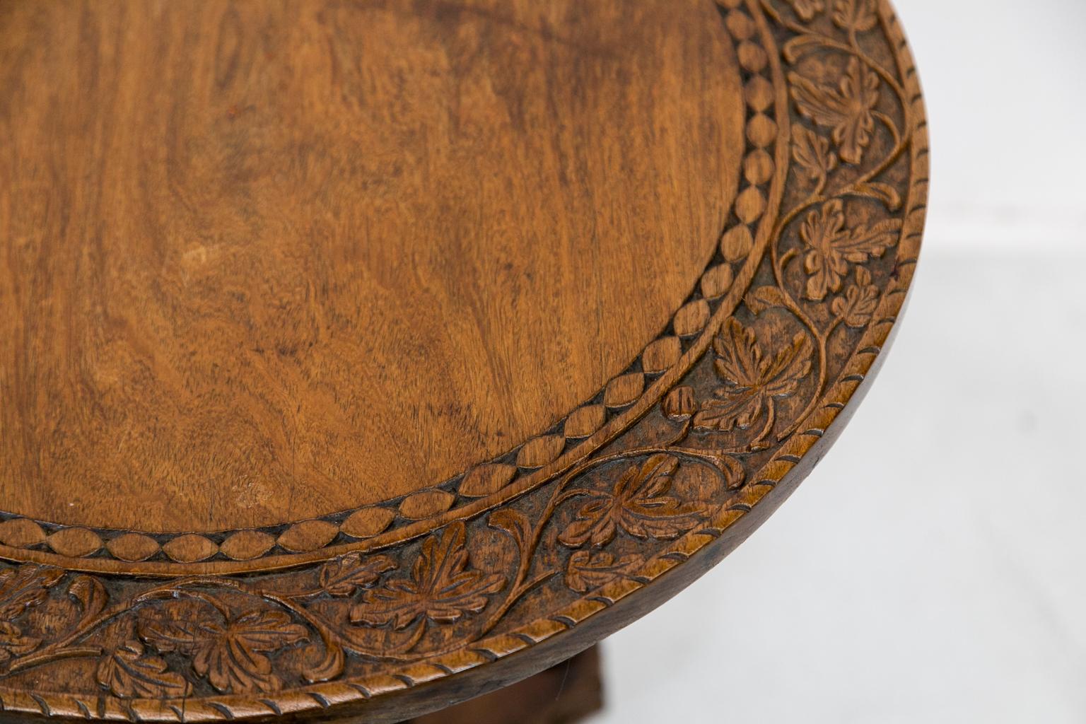 Anglo Indian carved tilt top table, with a quadrafoil platform base. It has an acanthus carved stem while the top is carved with a repeating leaf and vine motif.


 