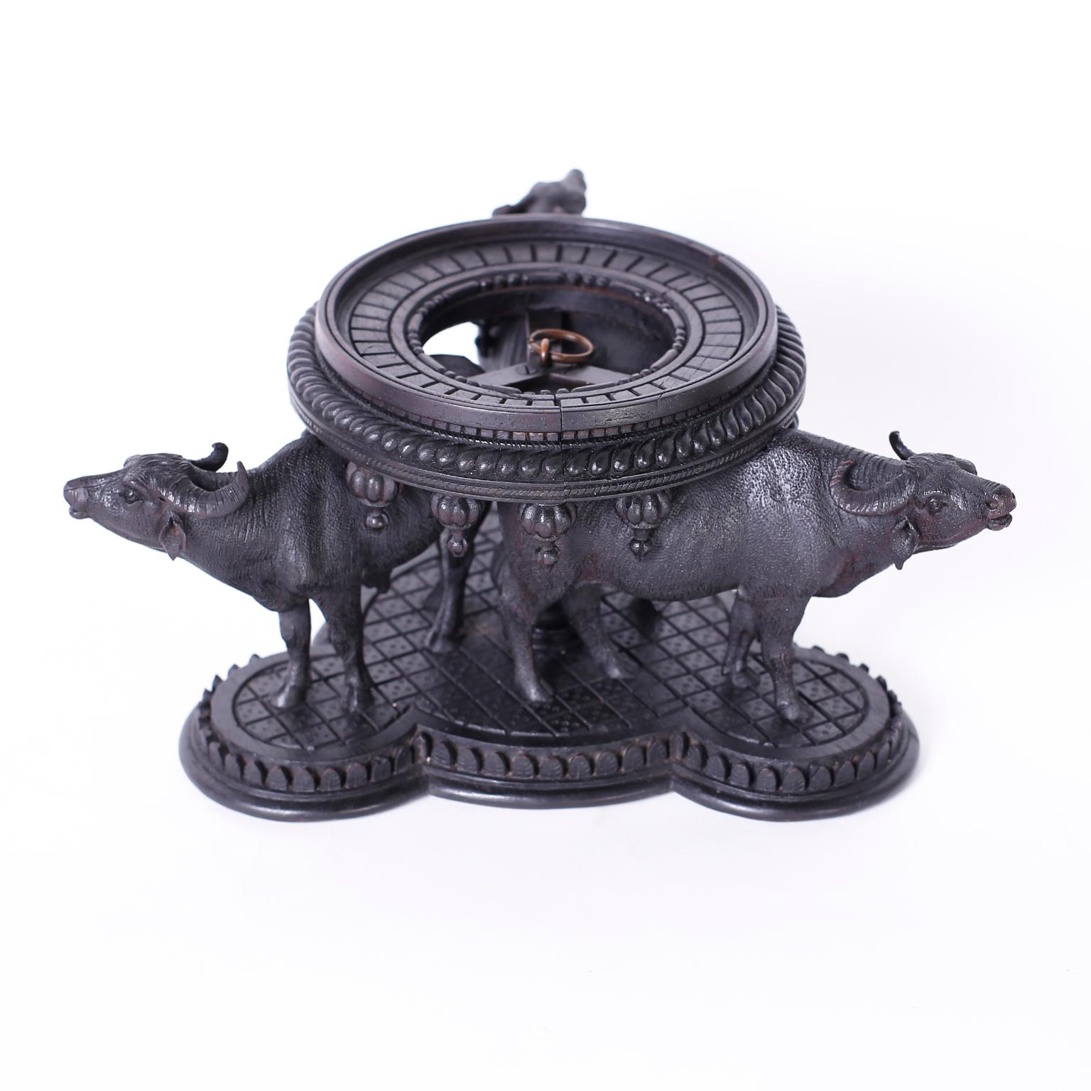 Intriguing antique Anglo-Indian stand masterfully carved from indigenous hardwood depicting three water buffaloes supporting a carved round molding.


