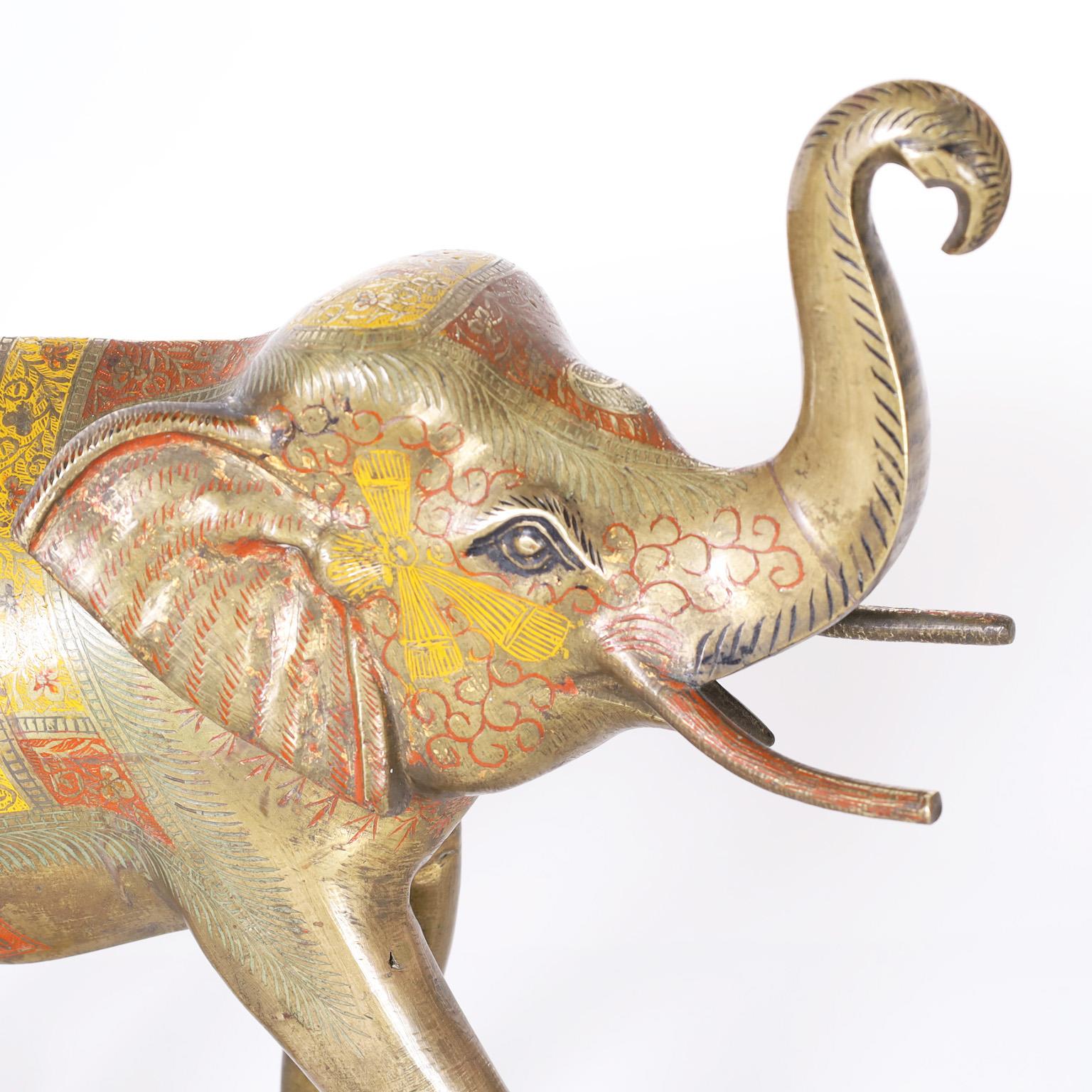 Anglo Indian cast brass elephant captured in mid strut and decorated with red and yellow enamel.