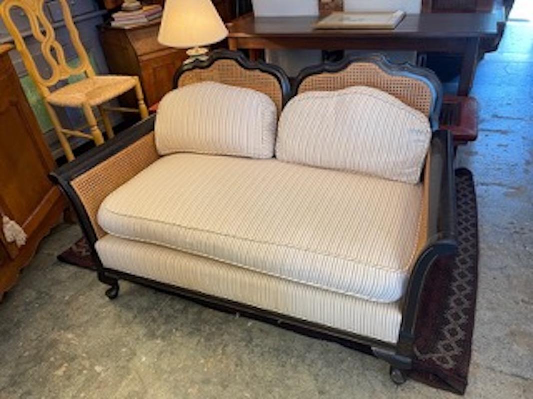 This is a beautiful 2 seater sofa with one large cushion, It has rattan on both sides and back with carved legs. It is made from ebonized teak wood. it is covered in the original fabric
