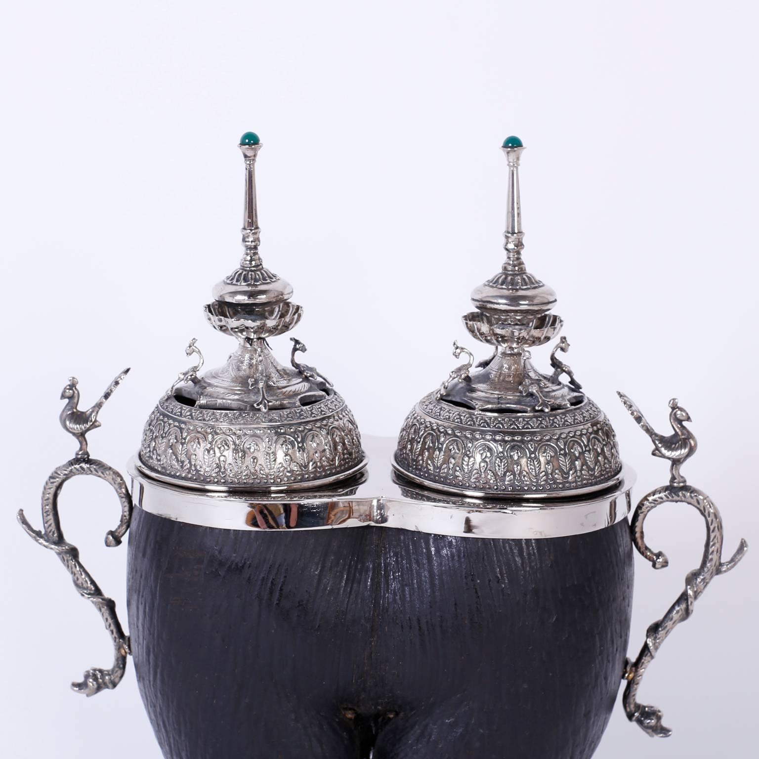Antique Anglo-Indian tea caddy expertly crafted in India, with a coco de mer
native to the Seychelles islands. Featuring two hand-hammered silvered metal
lids with stone topped finials and silver snake handles with phoenix
birds. The double
