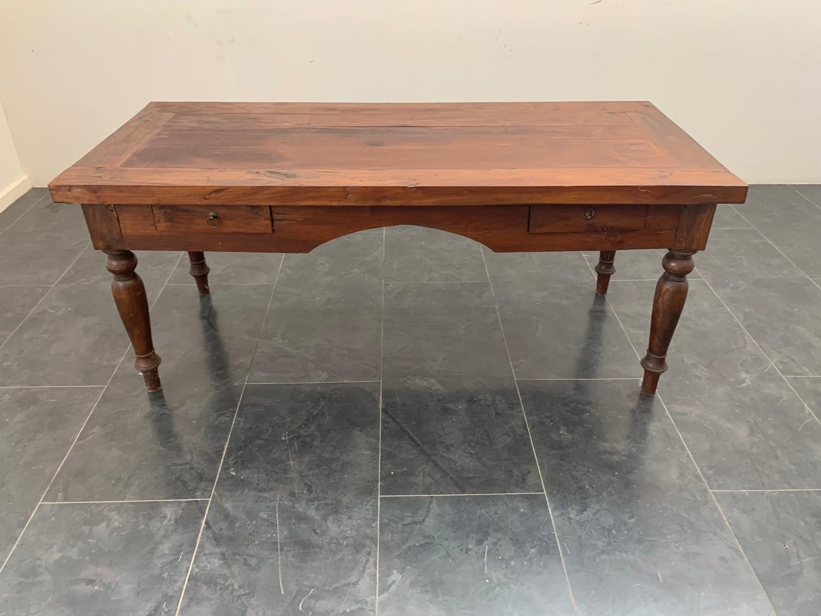 Grande e robusta scrivania della fine del 1800. Materiale in teak di spessore generoso. Al di sotto del profilo scolpito tipico dello stile e dell'epoca, sono visibili numerosi interventi di restauro eseguiti in passato. Segni d'uso