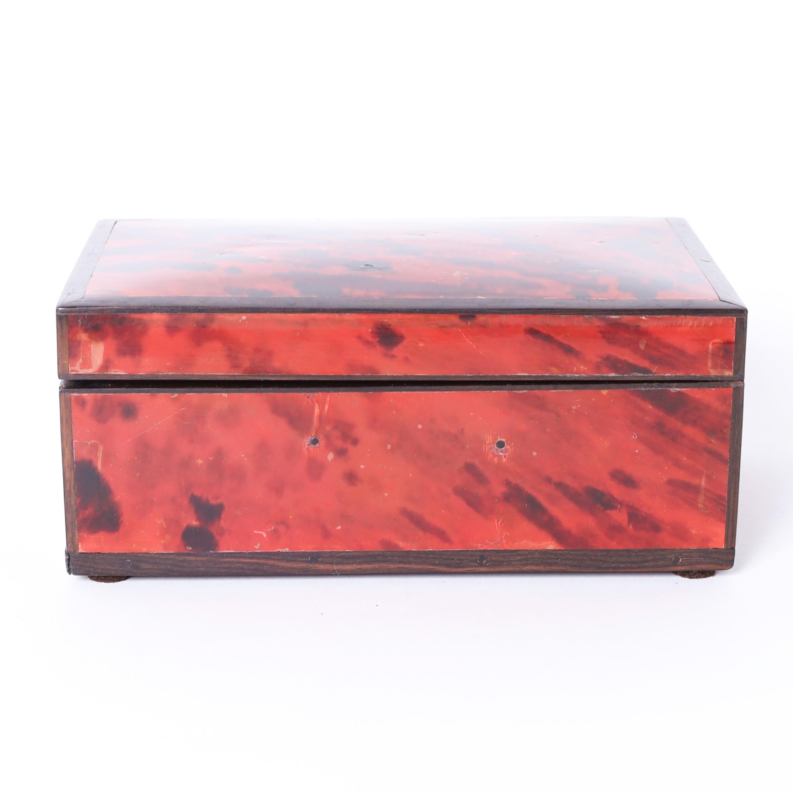 Inspired vintage Anglo Indian hinged box crafted in mahogany and clad in a faux tortoise laminate.
