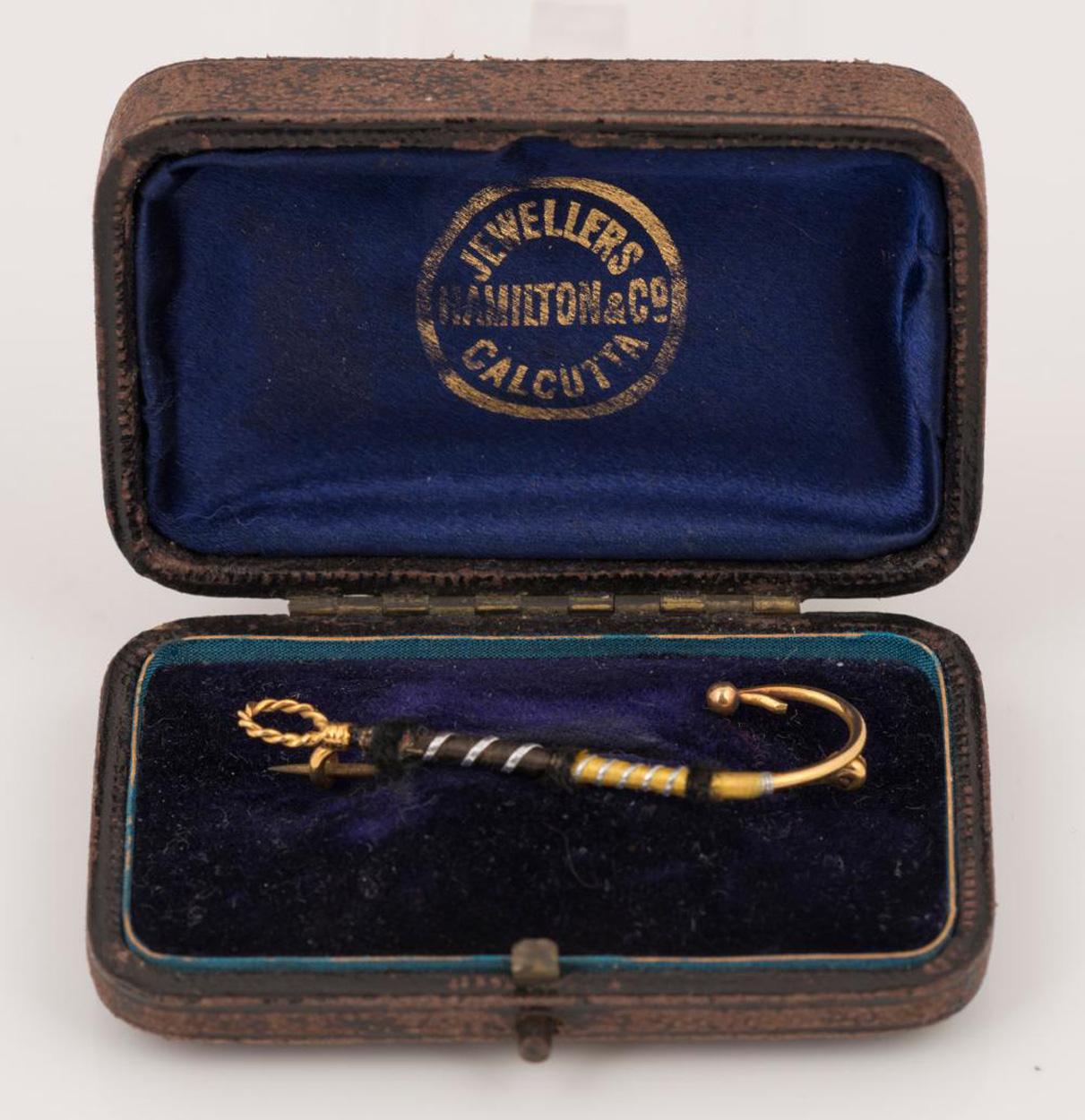 Raro y deseable broche de oro de 9 ct con forma de señuelo de pescador con mosca atado, vendido por Hamilton & Co, Calcutta,  1.7 gramos.

Robert Hamilton (1772-1848) llegó a la India y empezó a trabajar en Calcuta en 1808. En 1808 abrió su joyería