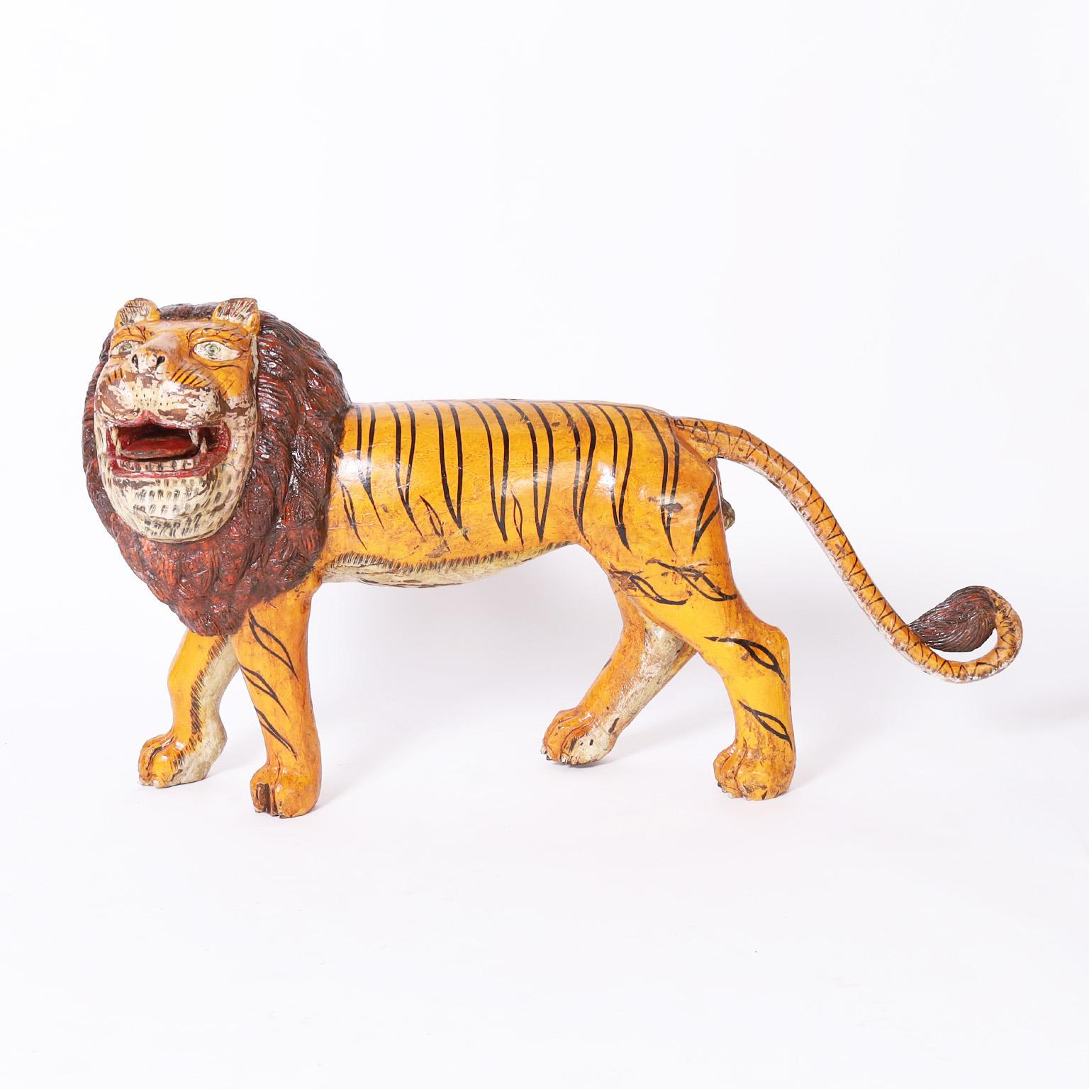 Sculpture rustique fantaisiste en acajou sculpté d'un gros chat avec une combinaison surprenante mais charmante de la forme d'un lion et des rayures d'un tigre. Il a conservé sa peinture d'origine, désormais usée à la perfection.