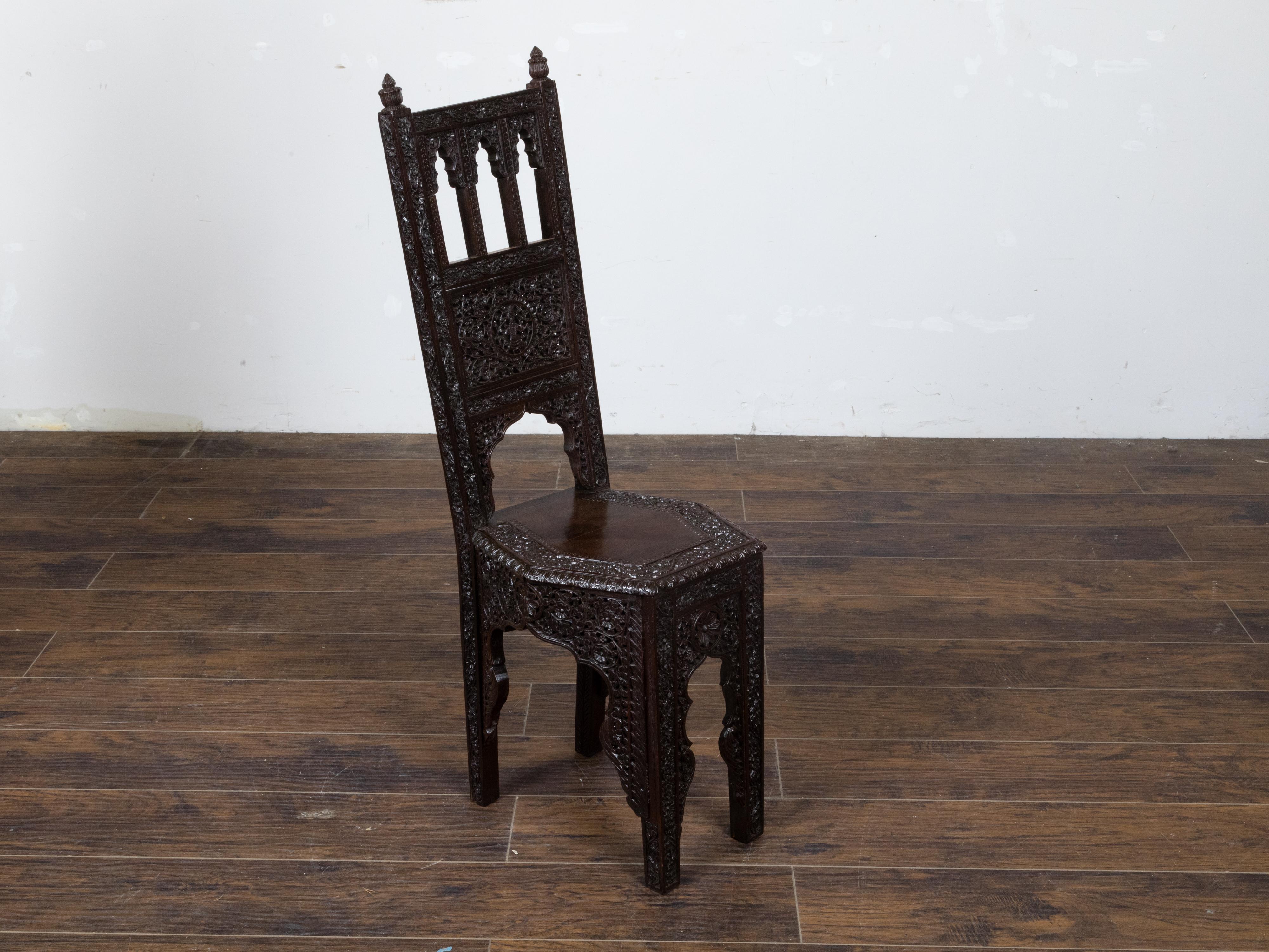 Chaise d'appoint anglo-indienne vers 1900 avec d'abondants et riches motifs floraux sculptés à la main, un feuillage en volutes, une assise hexagonale, des pieds sculptés et une patine foncée. Cette exquise chaise d'appoint anglo-indienne, vers