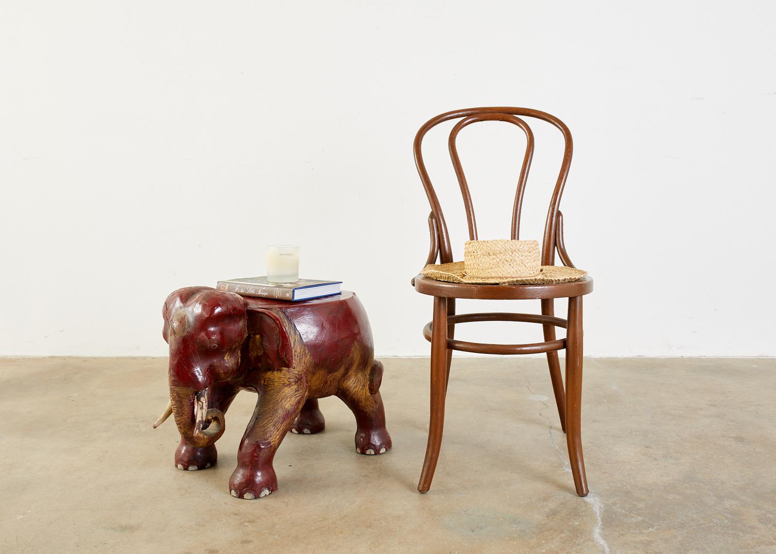 Remarkable Anglo-Indian hand carved elephant stool. Crafted from hardwood with a lacquered and parcel-gilt finish. Charming detail with a curled up trunk, white tusks, and big ears. From an estate in Hollywood, CA.