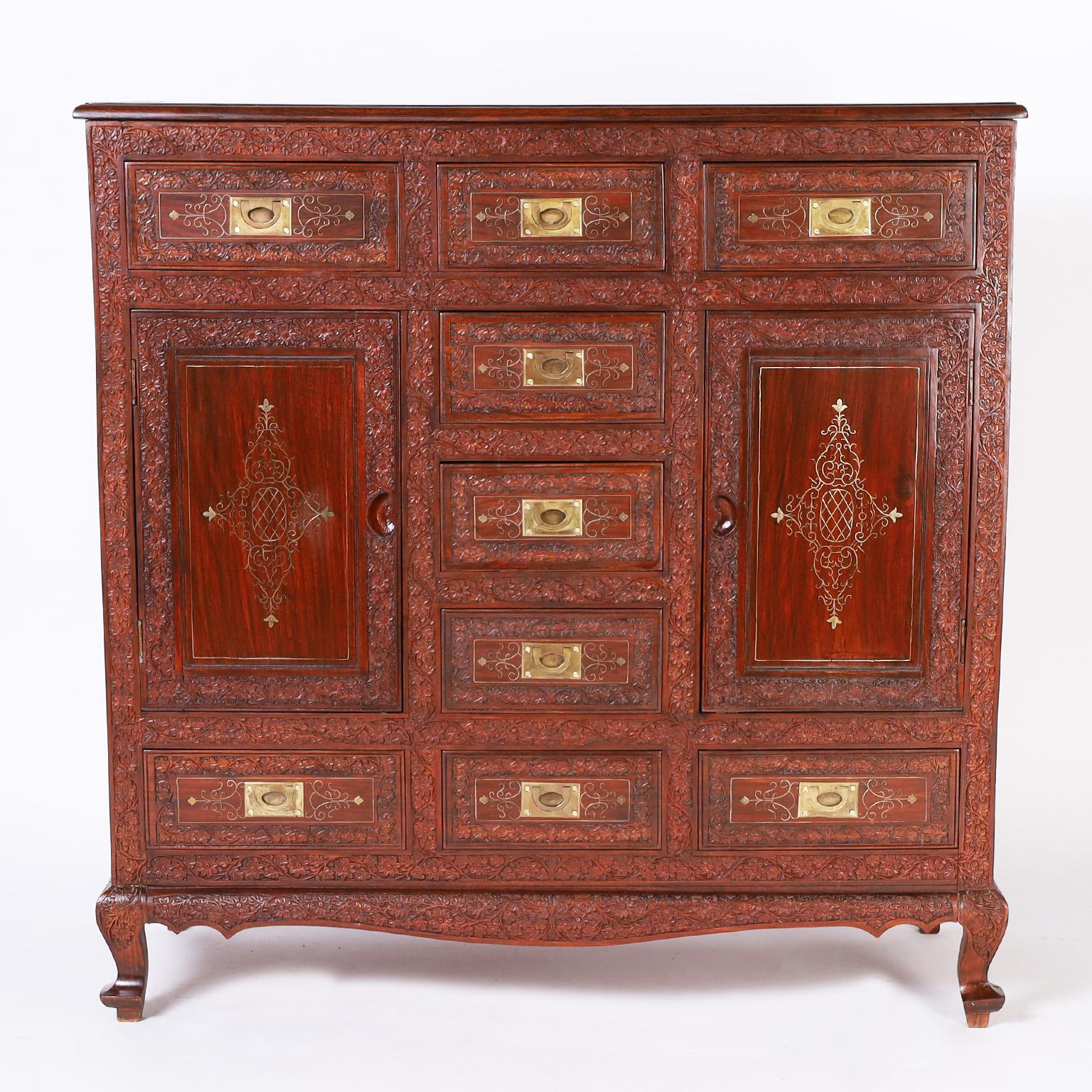 Antique Anglo Indian chest with nine drawers and two doors expertly crafted in well grained rosewood with all the bells and whistles, featuring ambitious floral carvings throughout, delicate floral brass string inlays on the top, sides, and front,
