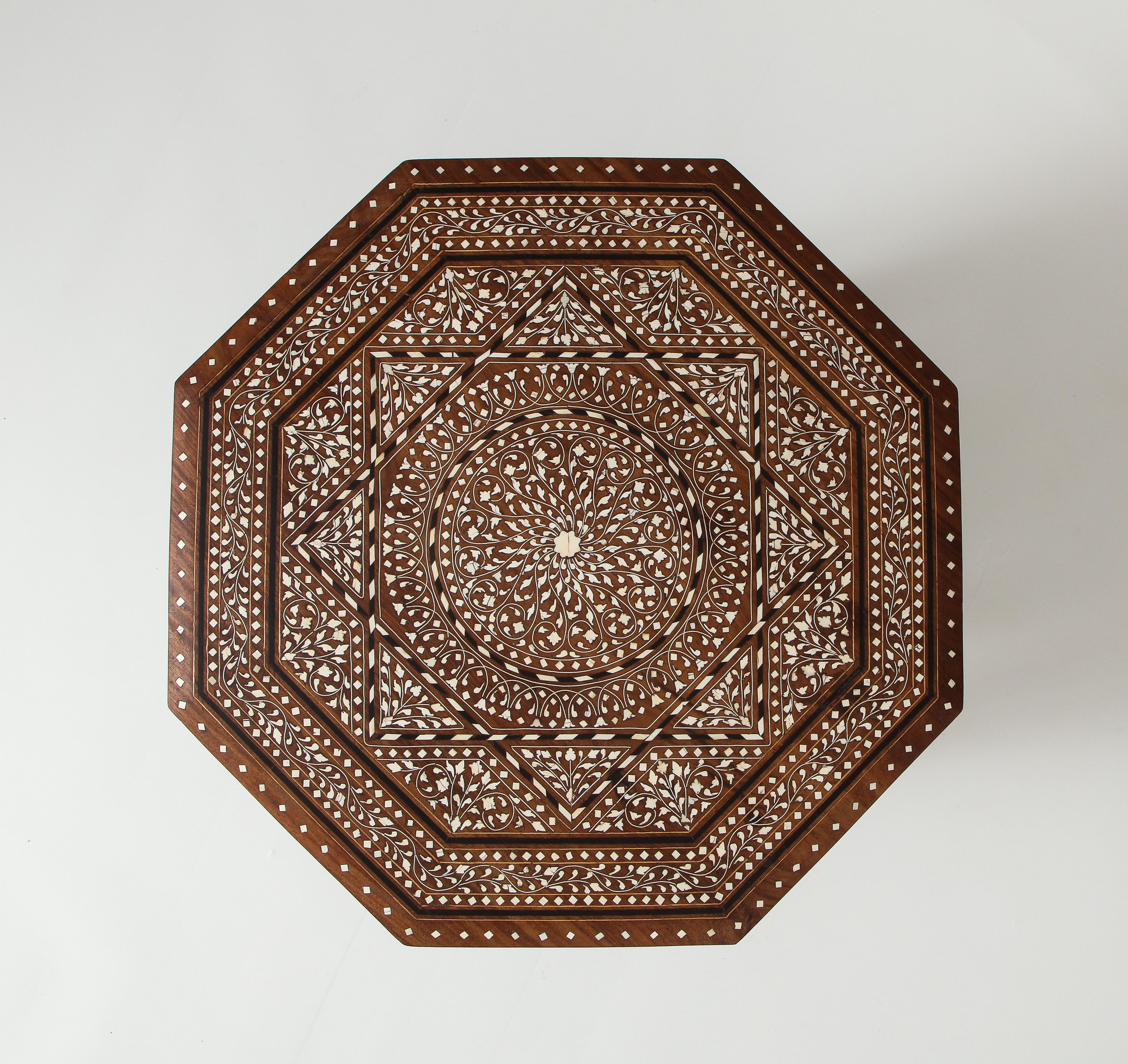 Made of richly hued hardwood finely inlaid throughout with bone in geometric patterns. The top lifts off with the base folding into itself to make this an easily transportable piece. A very attractive example of its type.