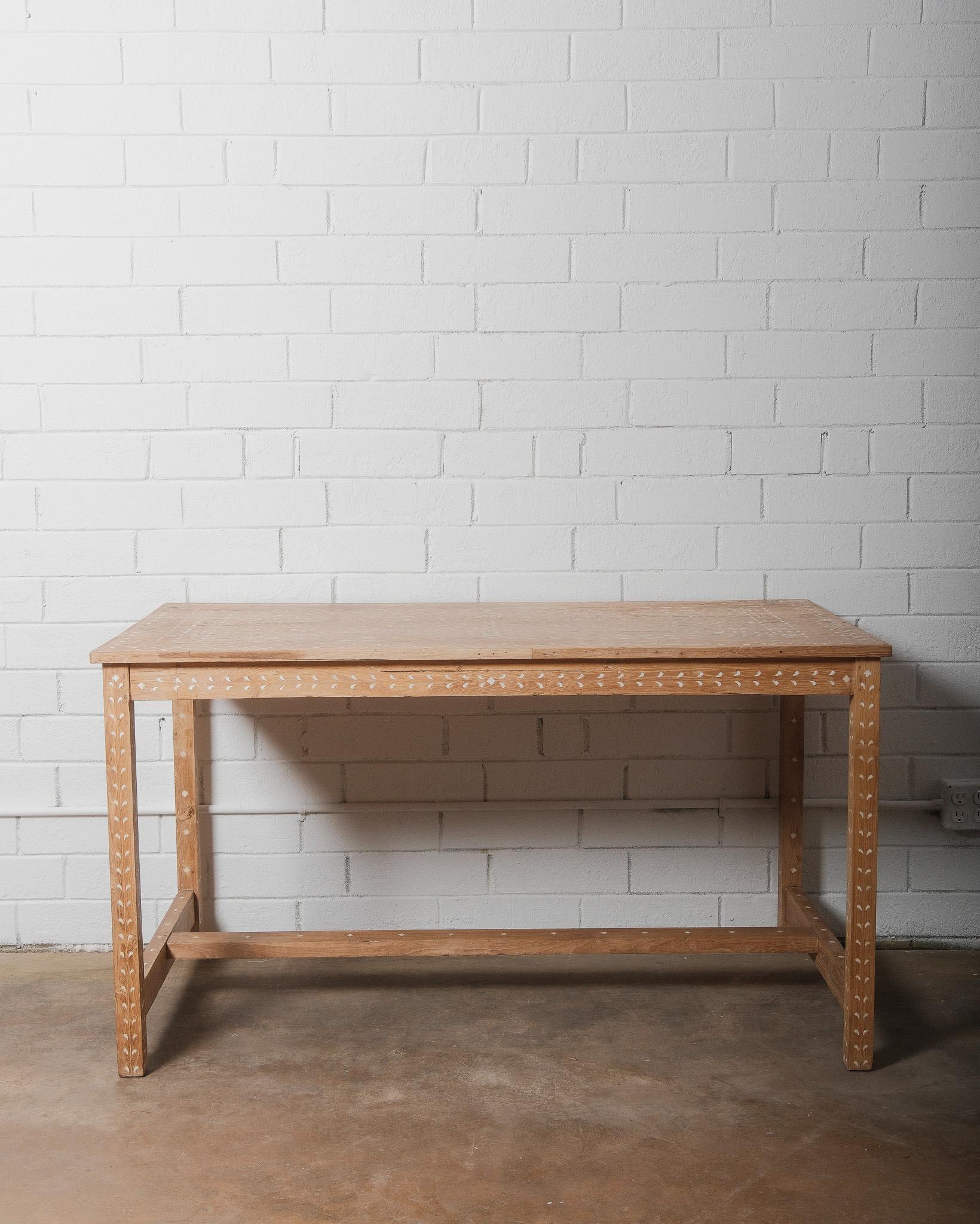 Esta mesa angloindia con incrustaciones es una auténtica obra maestra de artesanía aplicada a mano. Adornada con intrincados motivos florales y patrones decorativos, esta pieza muestra el antiguo arte de la intarsia, o incrustación de hueso, una