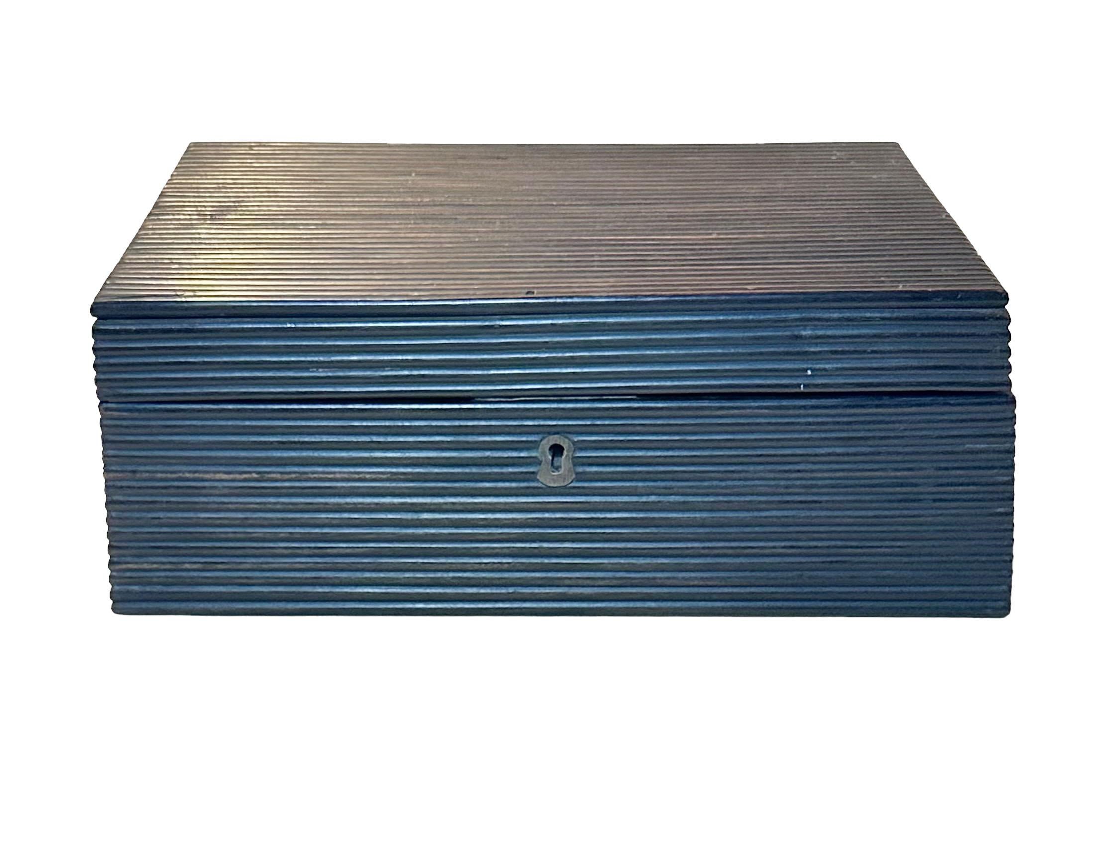 Una caja de trabajo angloindia de ébano. La bandeja se levanta de la caja de la tapa, que también tiene incrustaciones de marfil y ébano y un disco redondo de hueso firmado New Bedford 1810. Tiene nueve compartimentos y la parte superior de los