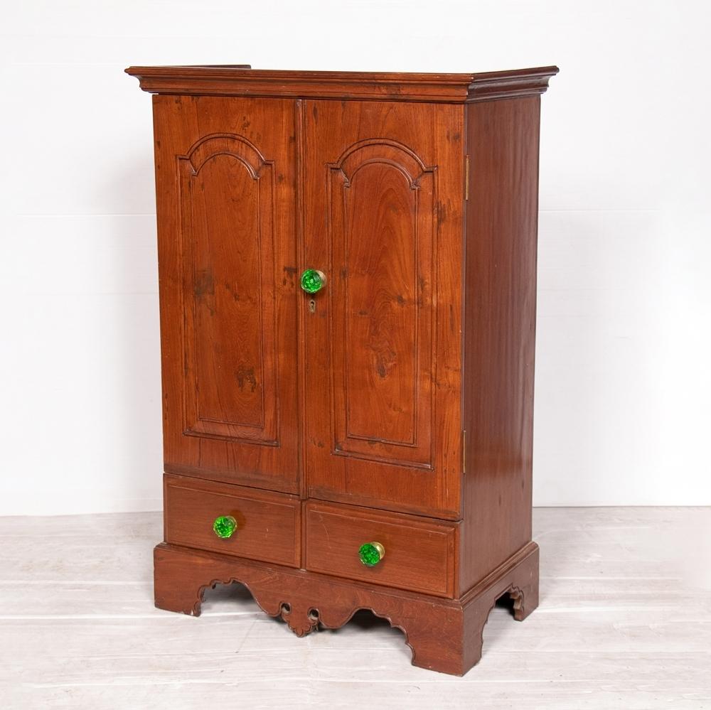 A mid 20th century Anglo Indian teak cabinet with two drawers, adjustable shelves and green handles.