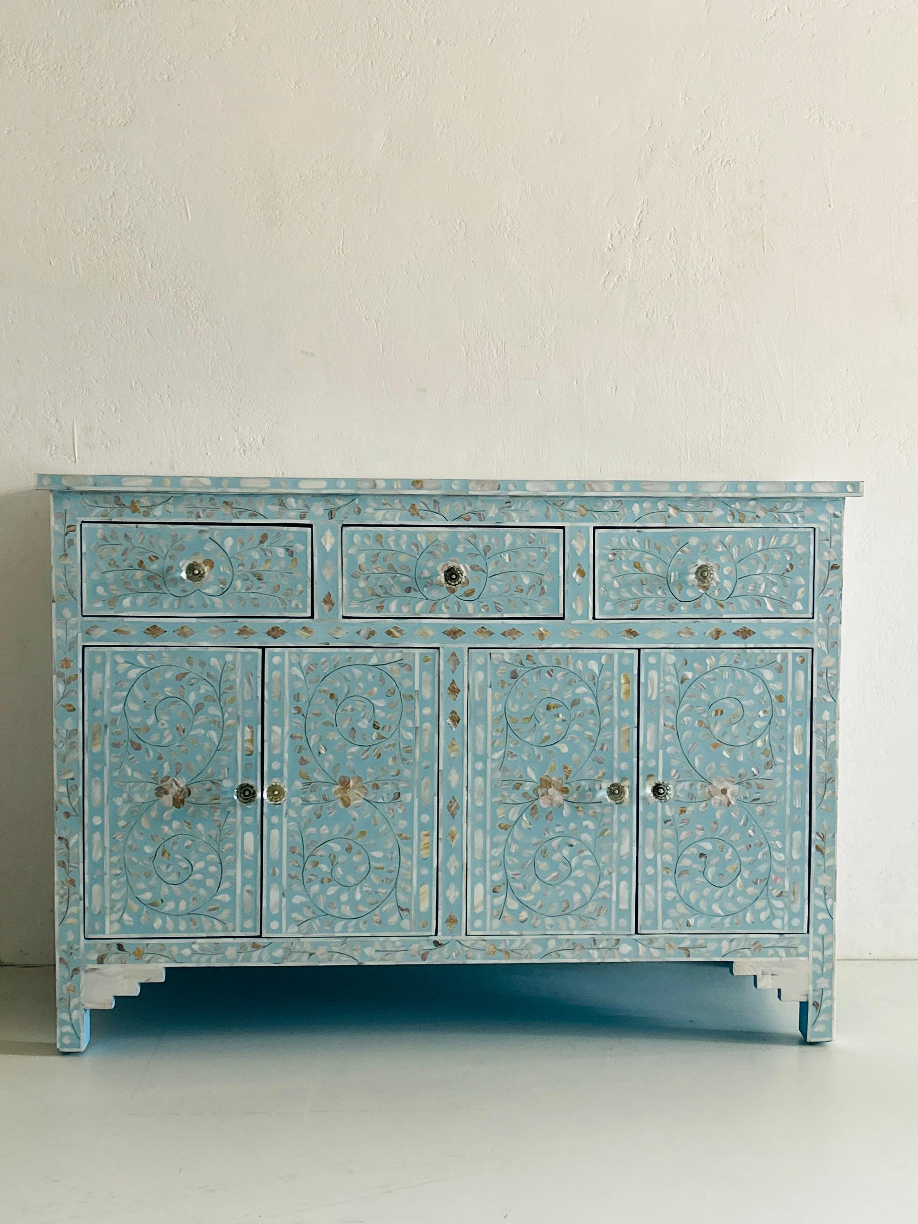 Das Blossom Pastel Sky Blue Sideboard ist eine atemberaubende Verschmelzung von von der Natur inspiriertem Design und fachmännischer Handwerkskunst. Handgefertigt aus Perlmuttteilen im Intarsienverfahren, entstehen wunderschöne Blatt- und