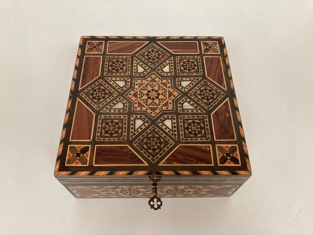 An Anglo-Indian sandalwood box with star pattern inlay of rosewood, ebony, mother of pearl and various other exotic woods. Lined with red velvet with lift out tray. Exquisite craftsmanship. Great gift idea.