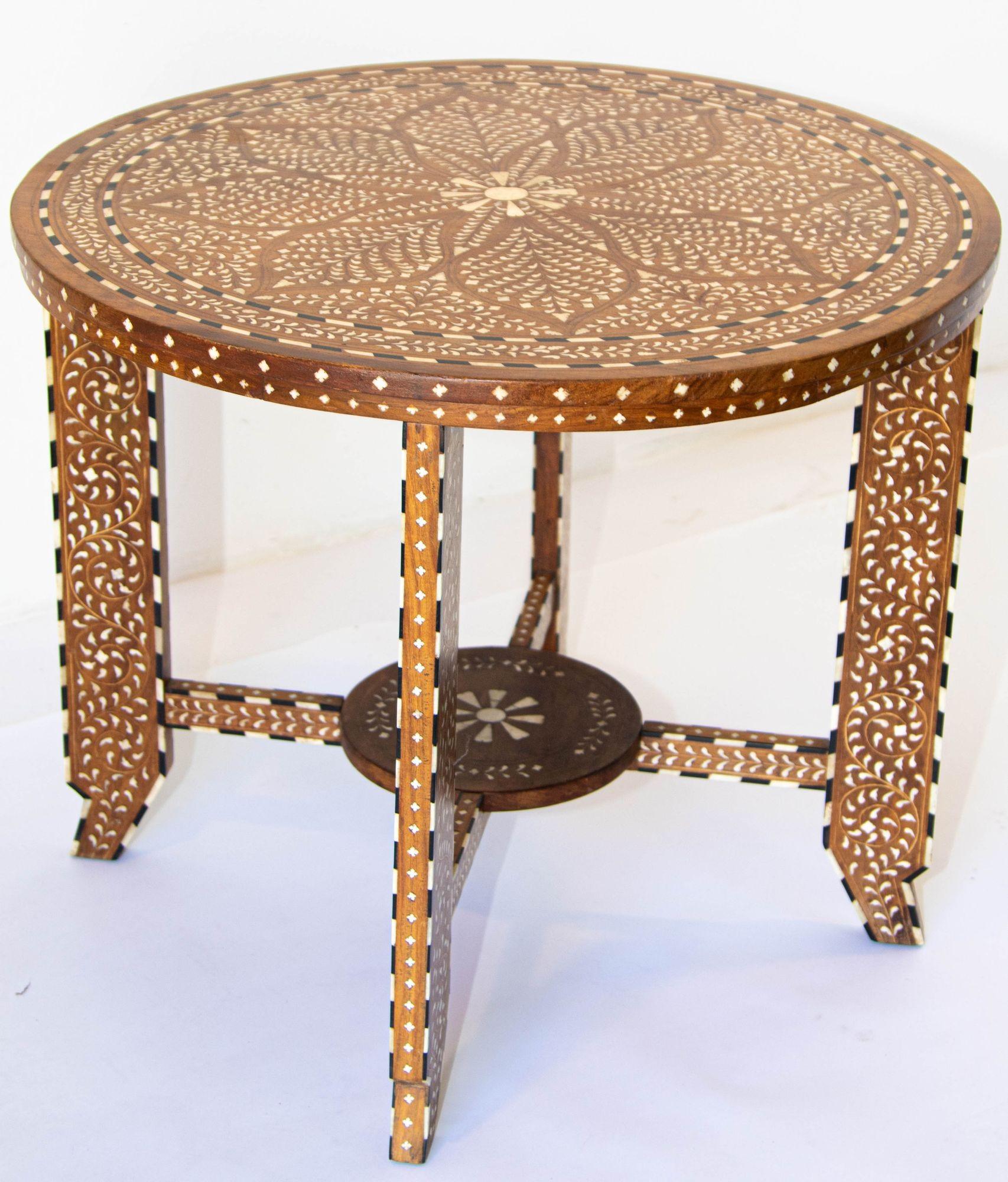Anglo Indian Mughal teak wood round side table heavily inlaid with camel bone.
Handcrafted from solid wood, this gorgeous piece showcases an intricate bone inlaid that displays a beautiful visual contrast on the table top and feet.
Indian occasional
