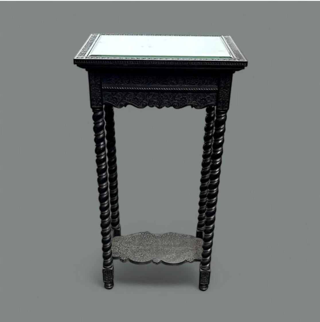 Présidence de Madras, vers 1860

Ebène avec plateau en miroir remplacé

Ce support sculpté de façon complexe est un exemple de l'artisanat anglo-indien du milieu du XIXe siècle, mêlant les formes domestiques britanniques à la virtuosité artisanale