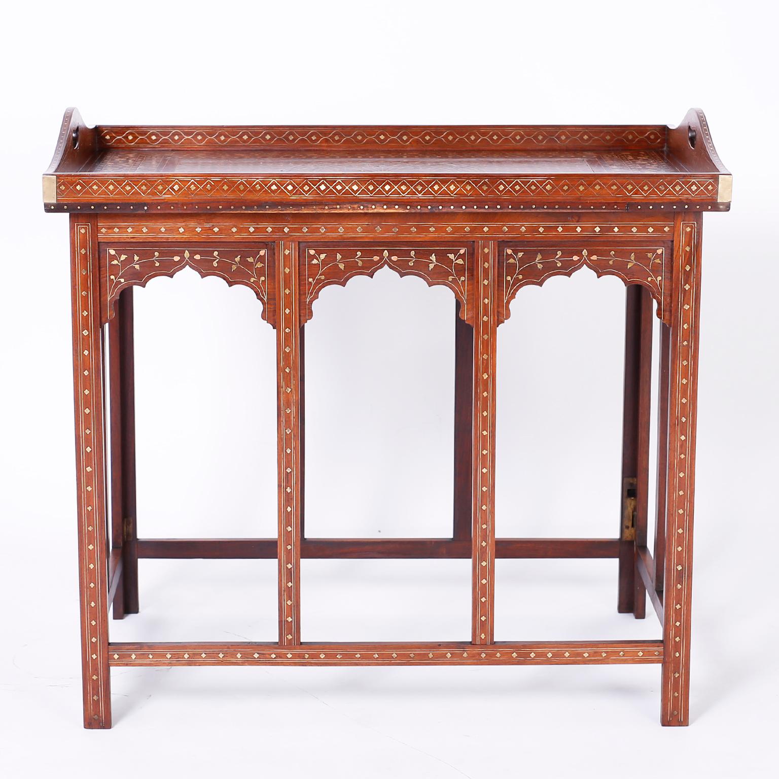 Antiker anglo-indischer Tisch aus Palisanderholz mit abnehmbarem Serviertablett auf der Oberseite, das mit zarten Blumenmustern aus Kupfer und Messing kunstvoll eingelegt ist. Der Sockel hat architektonisch interessante Rundbögen und ist mit