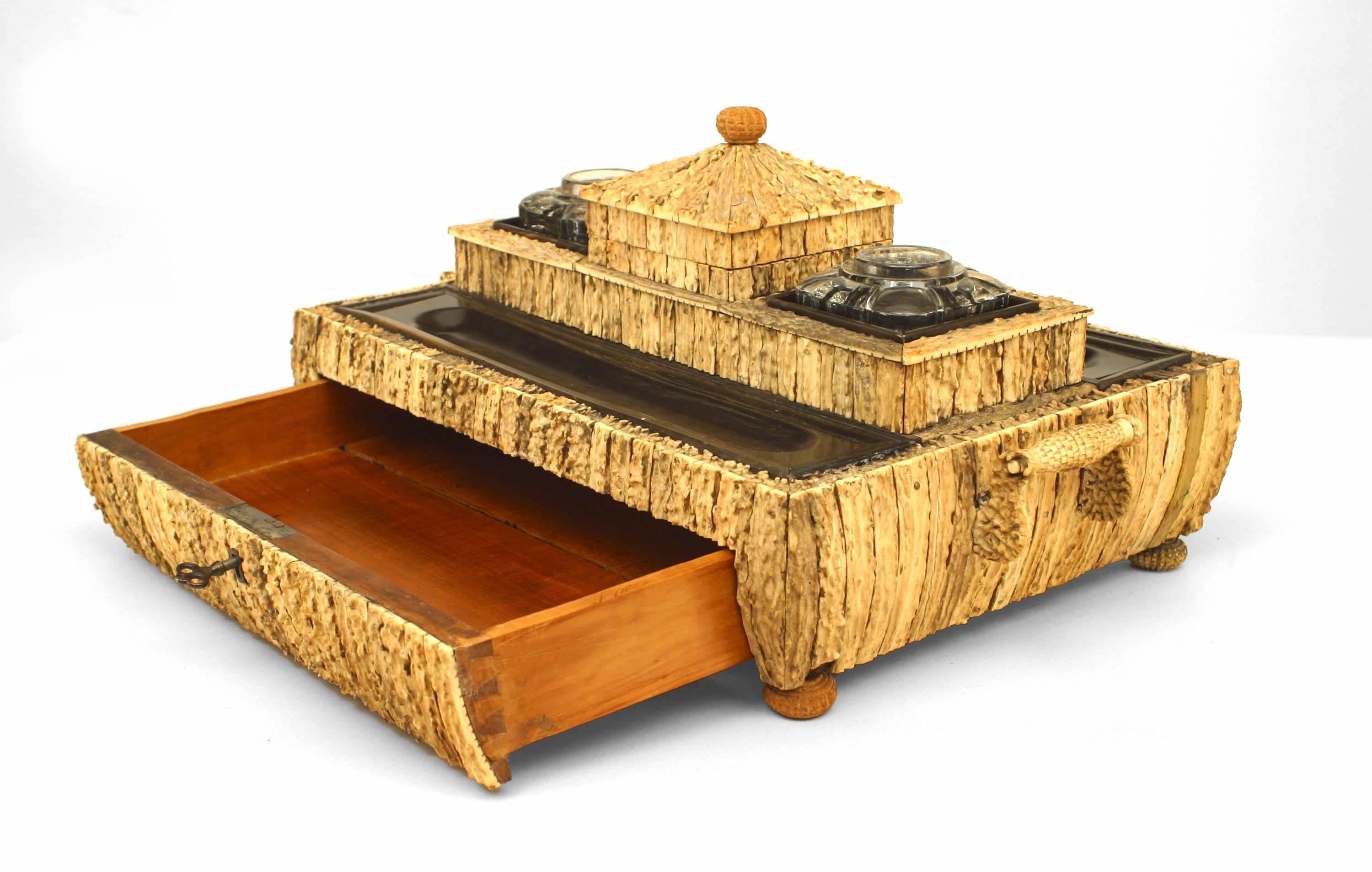 Écritoire en bois de santal plaqué de bois de cerf, de forme rectangulaire, avec deux encriers en verre au-dessus d'un tiroir (Vizigapatam).
  