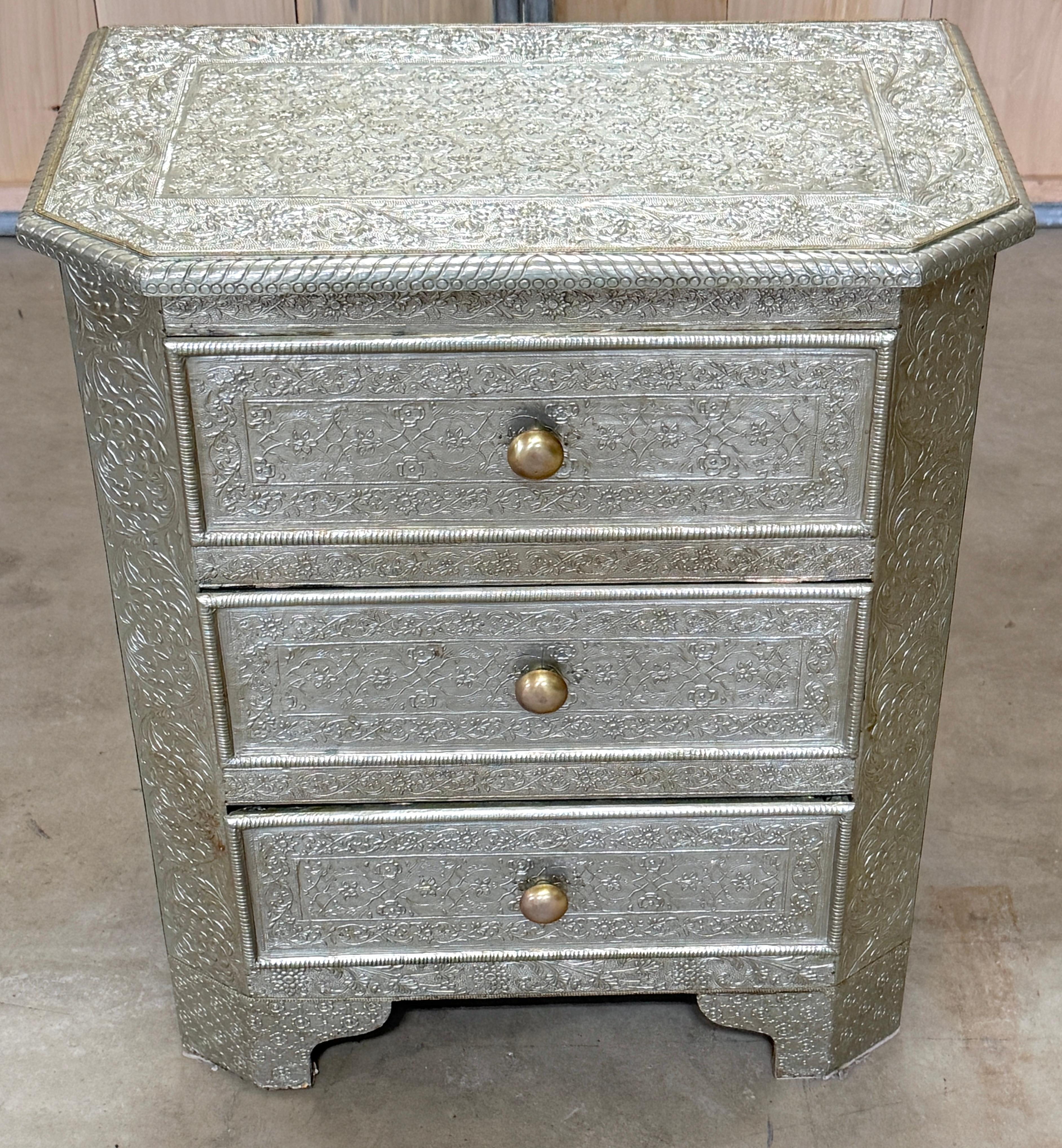 Anglo-Indian Silver Clad Repoussé Three Drawer Chest or Nightstand 

A stunning example of Anglo-Indian craftsmanship, this silver-clad three-drawer chest or nightstand is an exquisite blend of traditional artistry and colonial-era elegance.